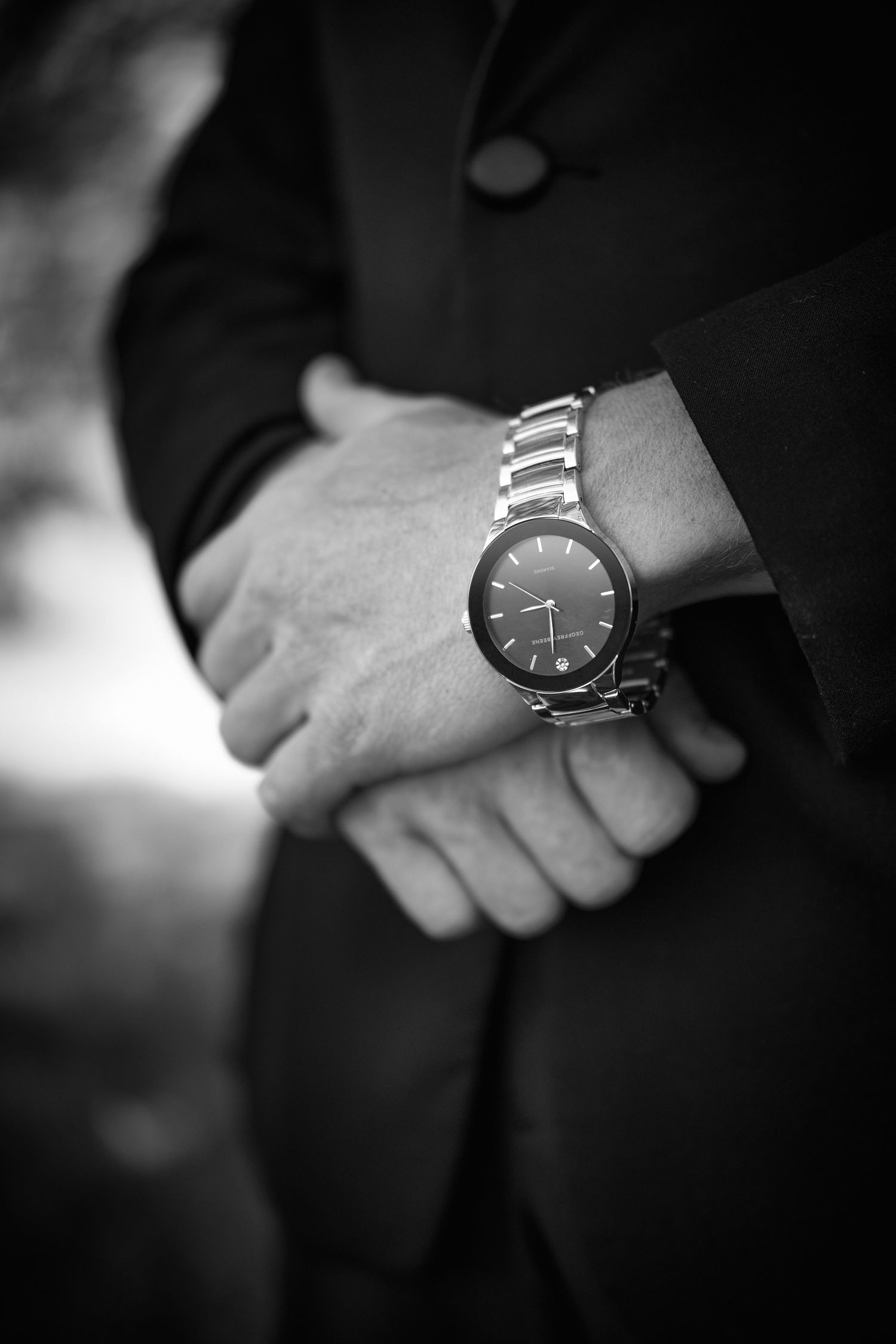 Close-up black and white detail shots of elegant watches worn at a formal event.