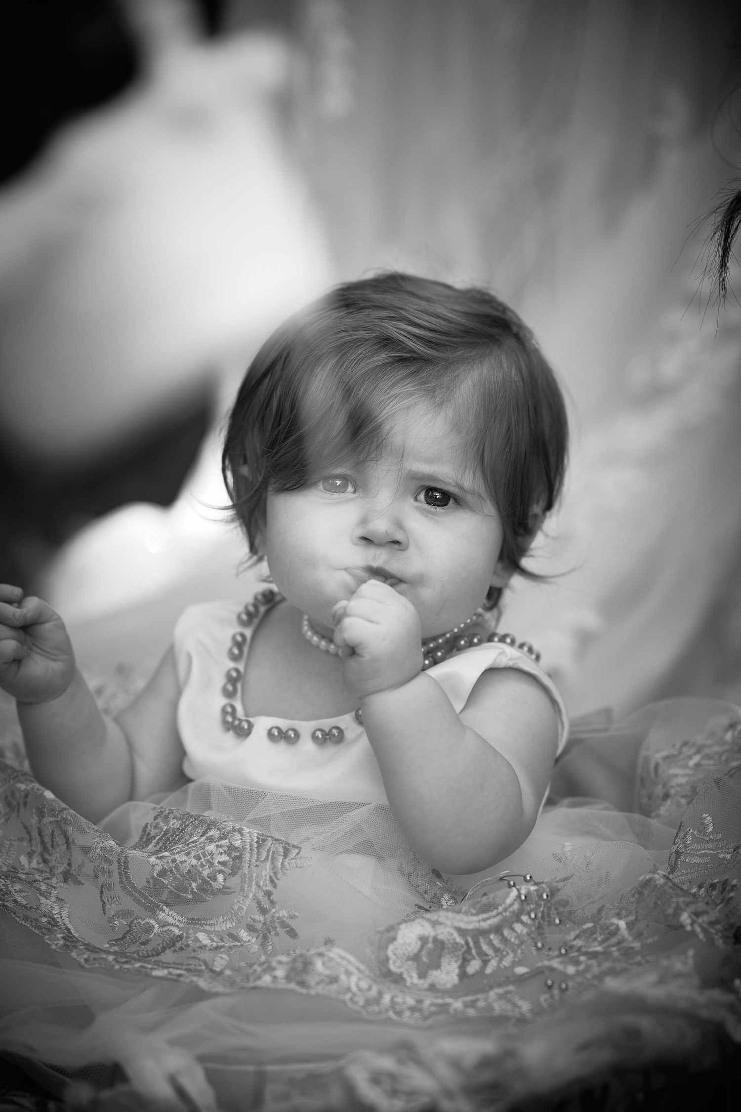 Sweet black and white portraits of a baby in delicate lace clothing.