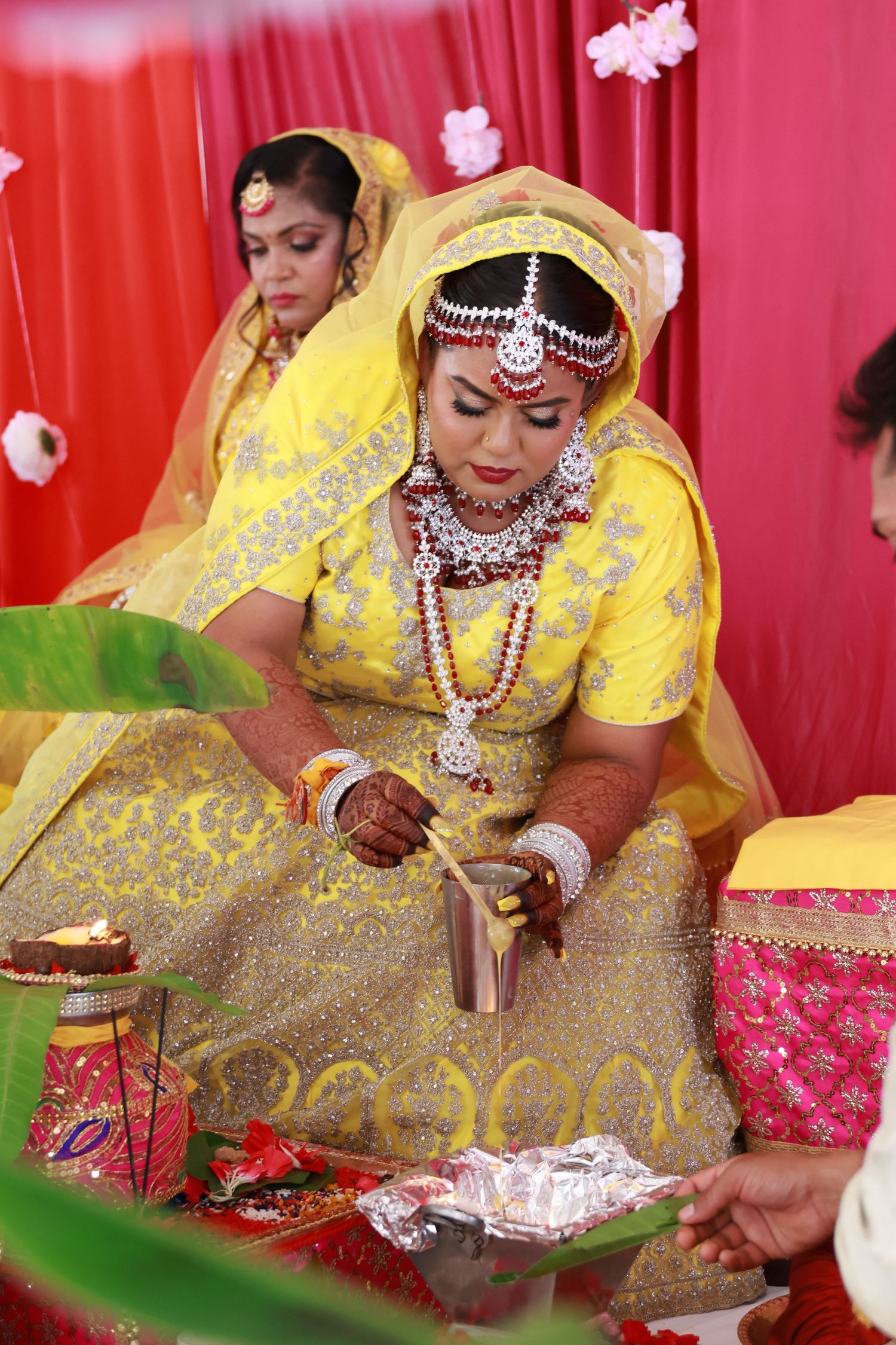 Traditional Indian wedding ceremony with yellow and red decorative elements.