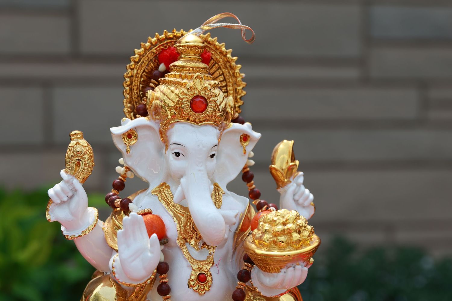 Decorative white and gold Ganesh statues arranged in a row.