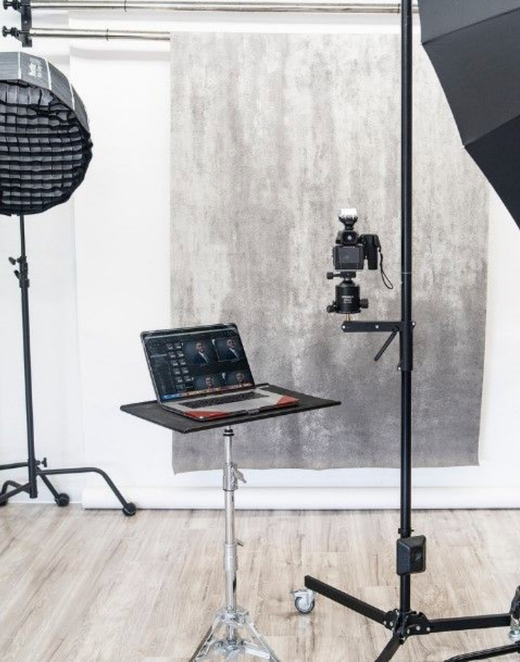 Photography studio setup with laptop, lights and camera equipment.
