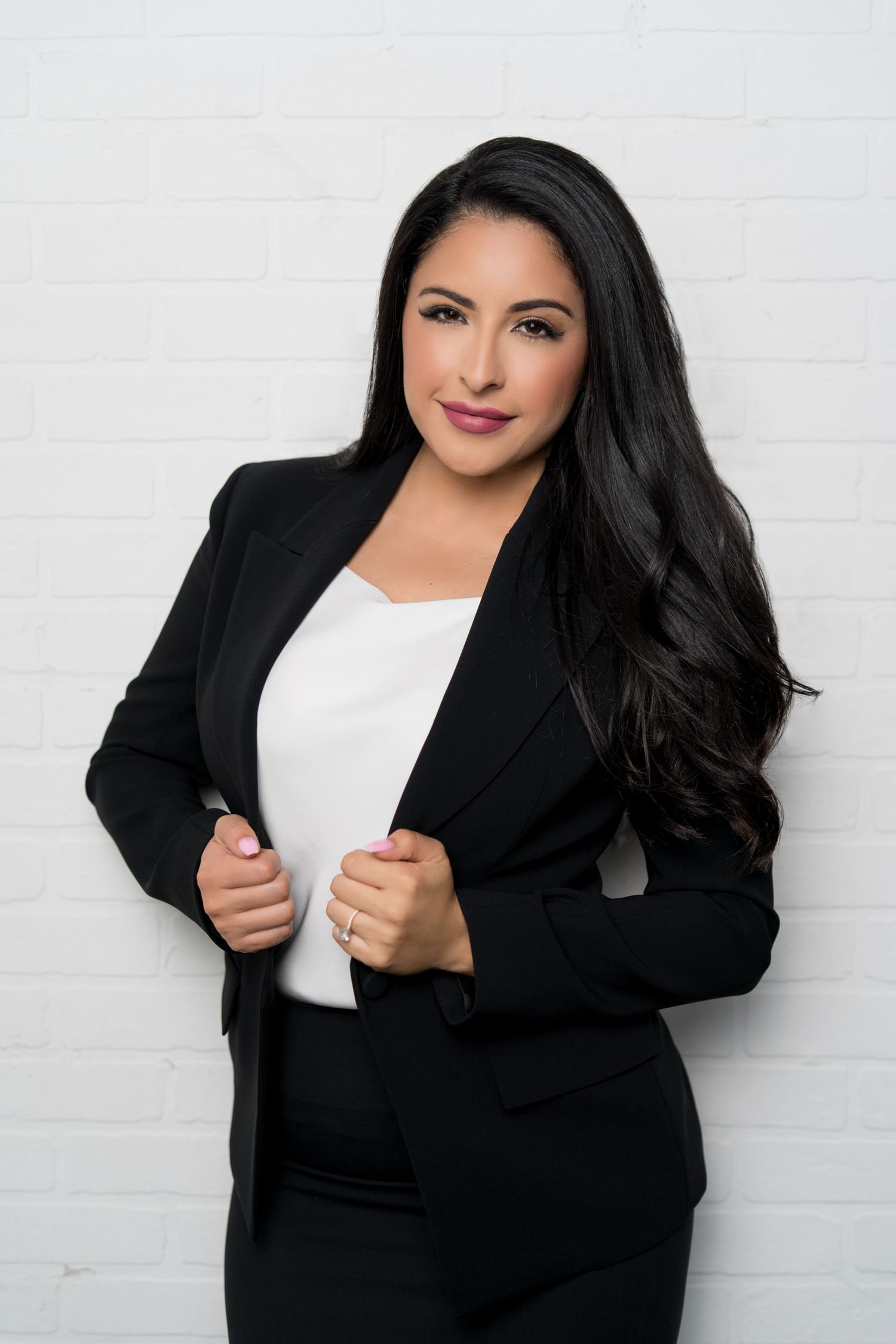 Professional portrait photo series featuring a person in a black blazer and white top against a light background.