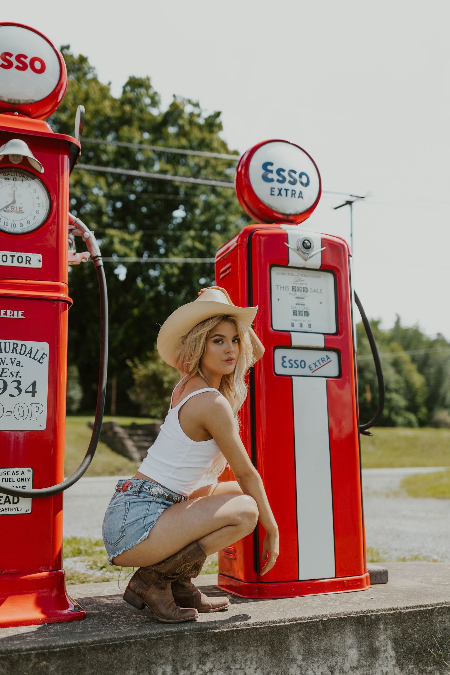 Classic red Esso gas station pumps with retro styling and round branded signs on display.