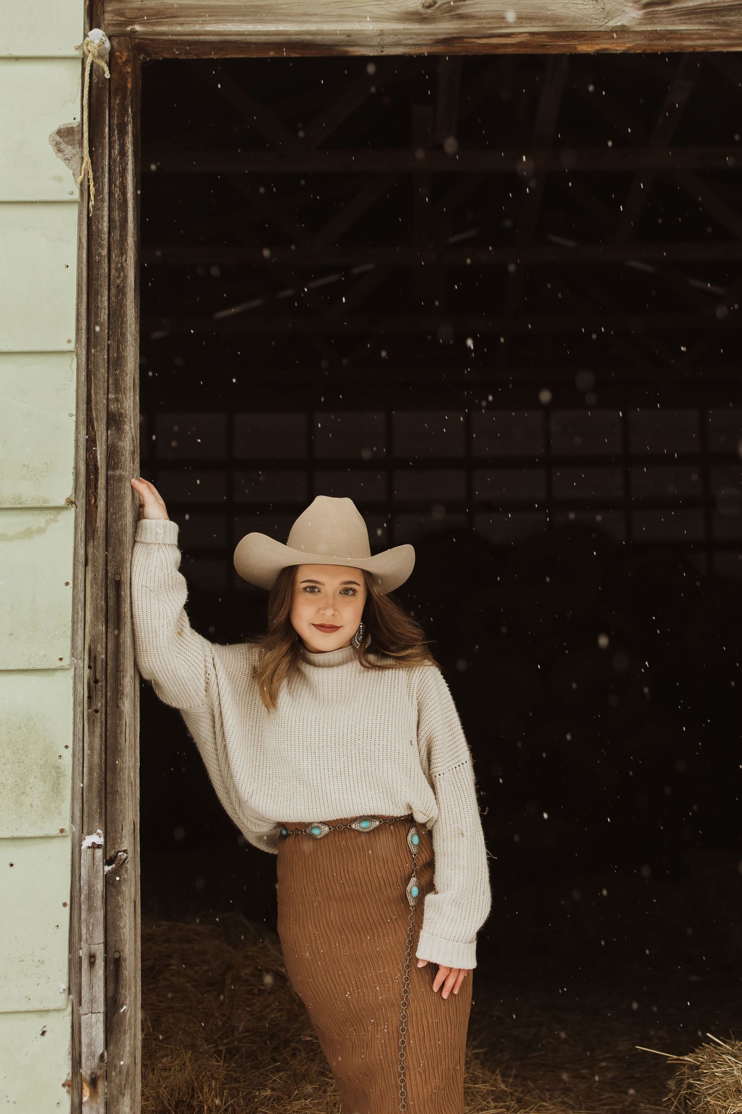A cozy winter fashion scene in a rustic barn doorway.