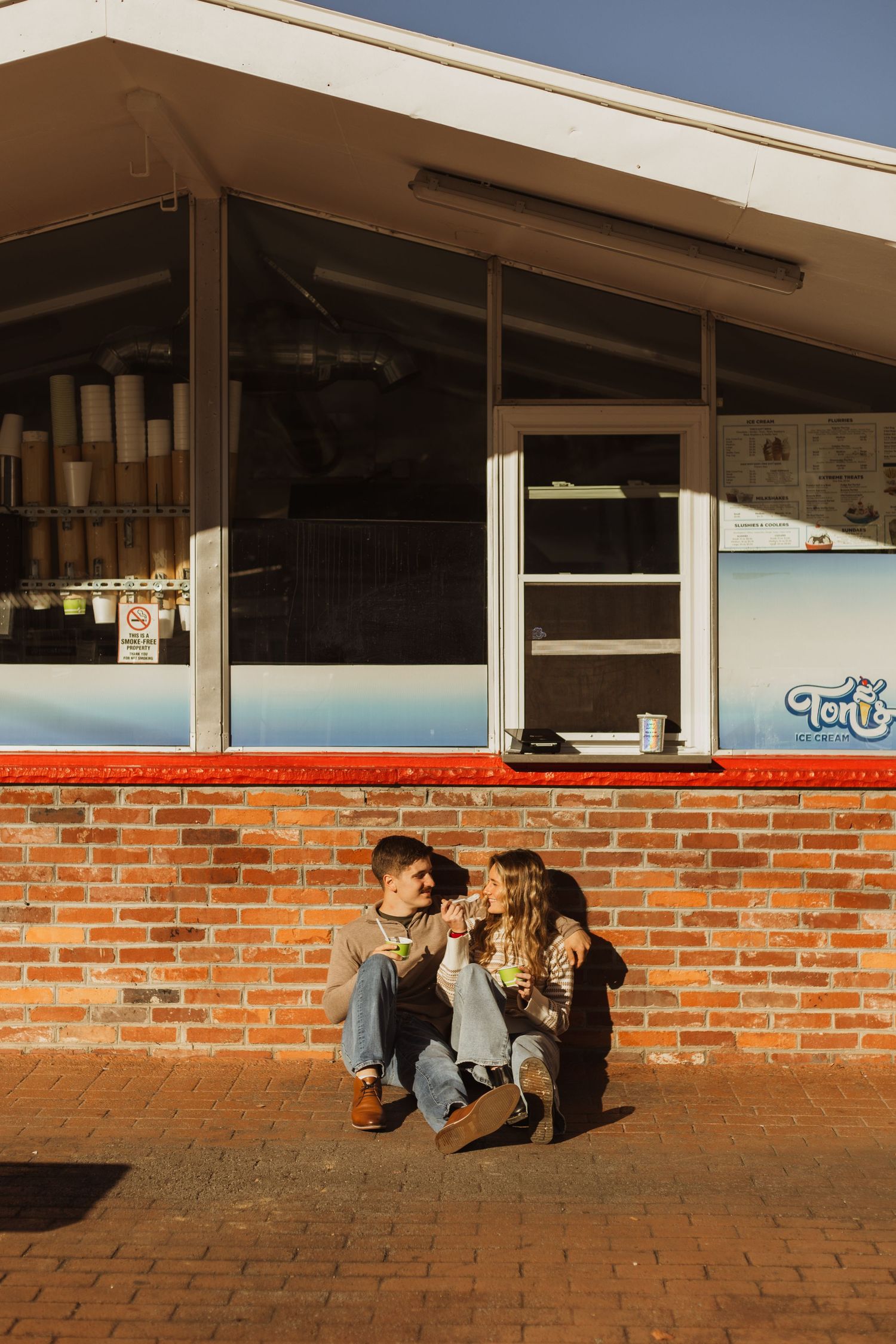 Friends sharing drinks outside brick building with blue painted wall.