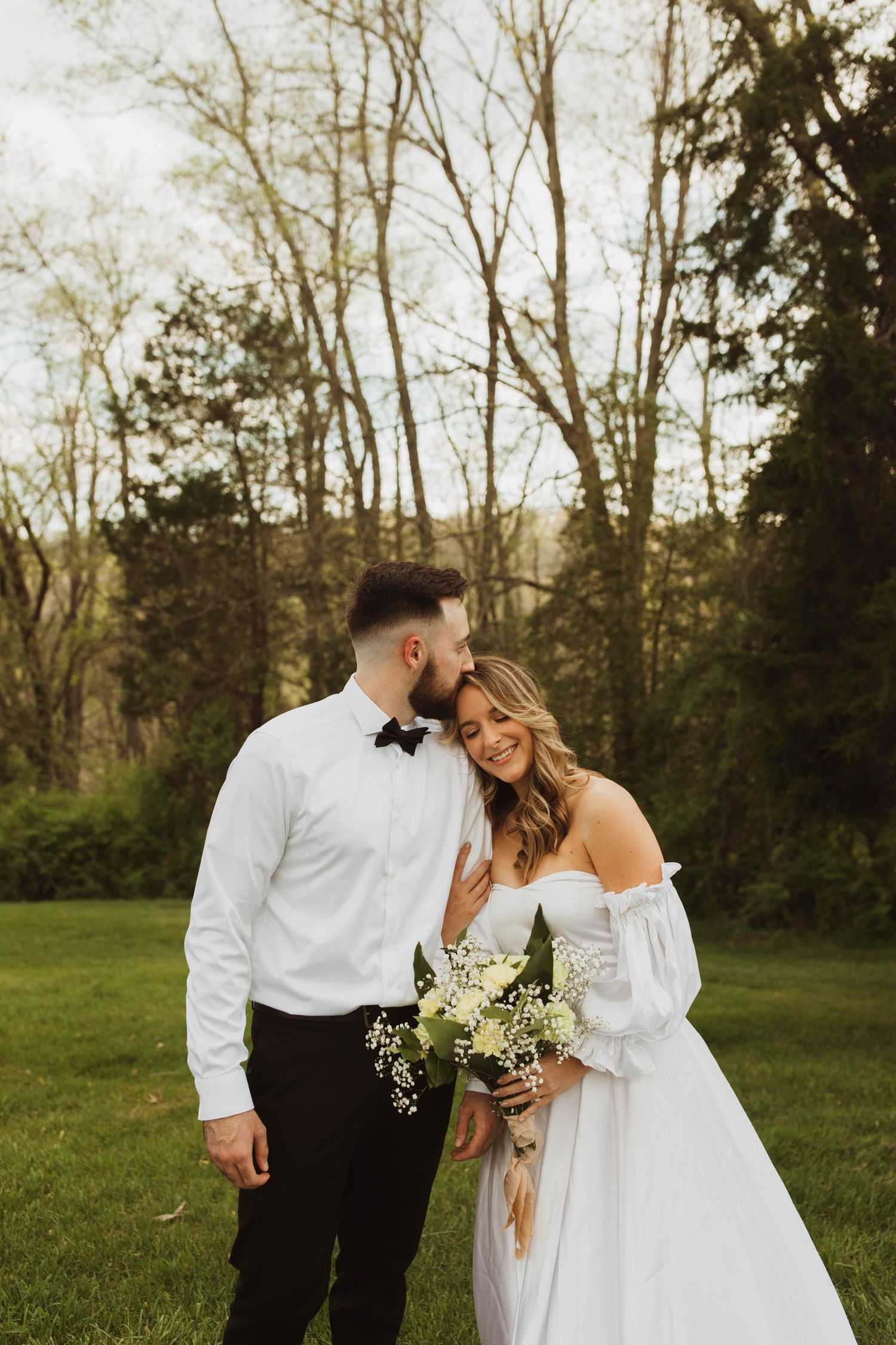 A romantic wedding portrait of a couple in a scenic outdoor setting with natural lighting.