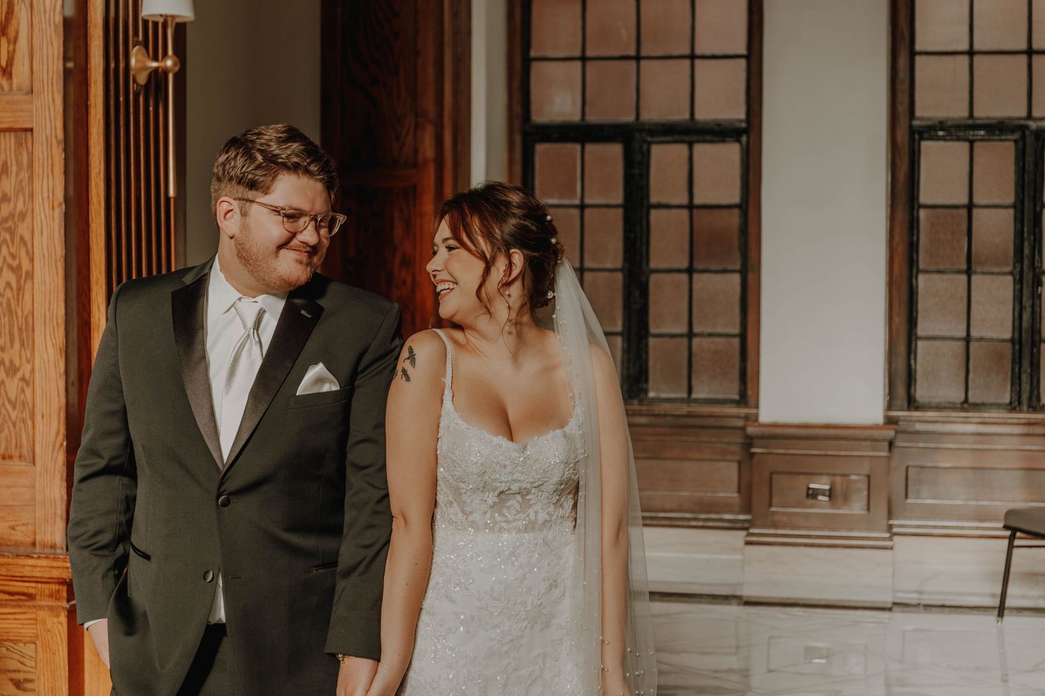 Intimate wedding portrait taken in front of rich wooden columns and vintage architecture.