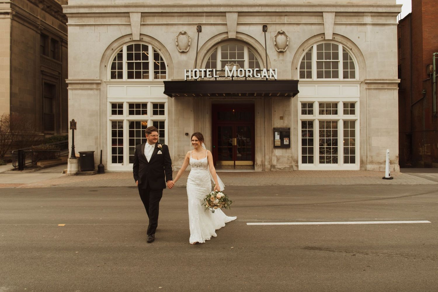 A couple walks outside the classic Hotel Morgan entrance in warm vintage tones.