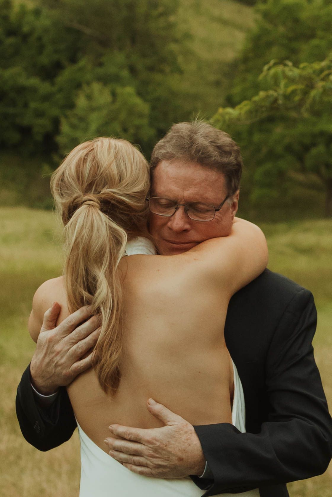 Emotional moment shared between two people during outdoor wedding celebration.