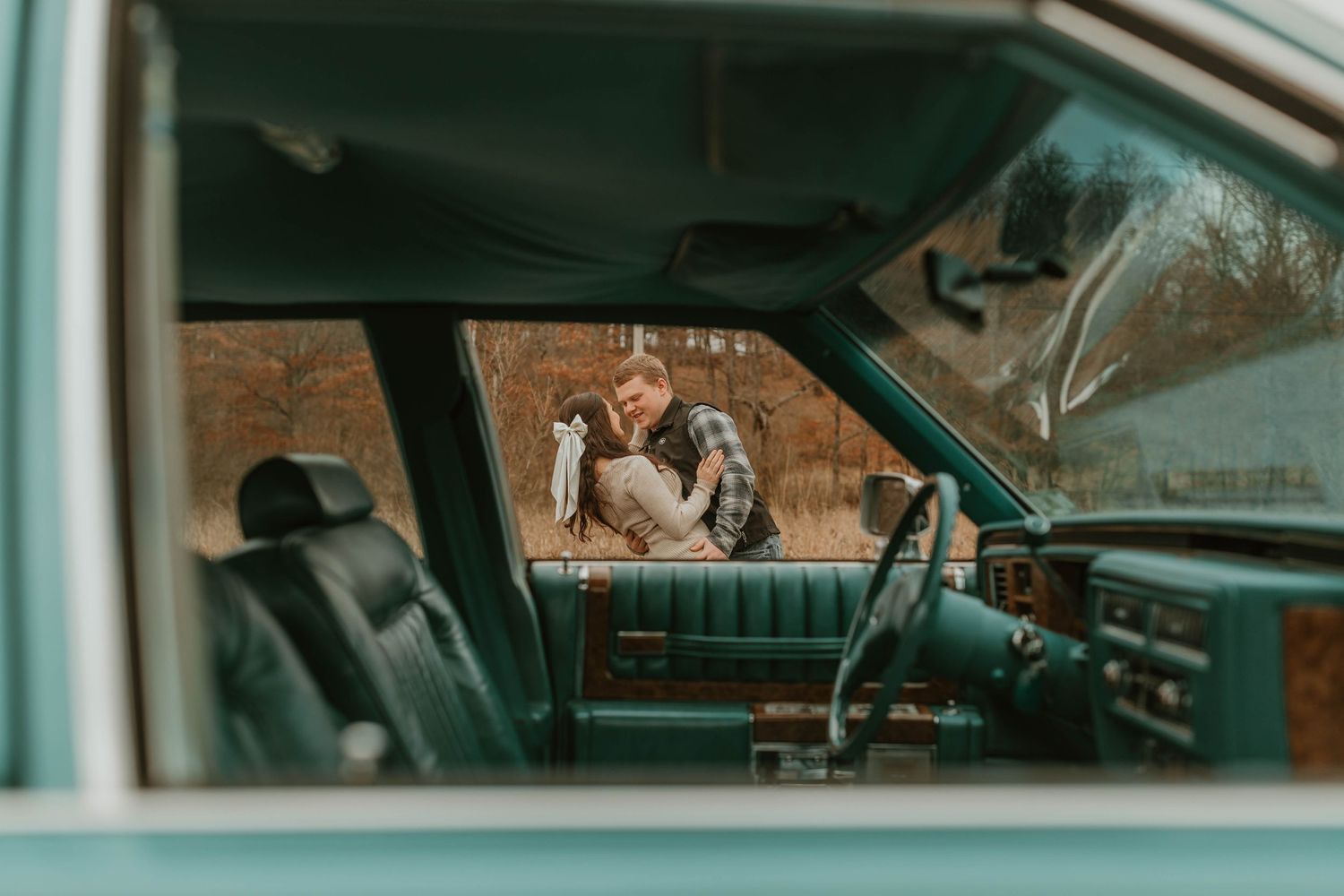 View through a vintage car window showing a romantic moment outside.