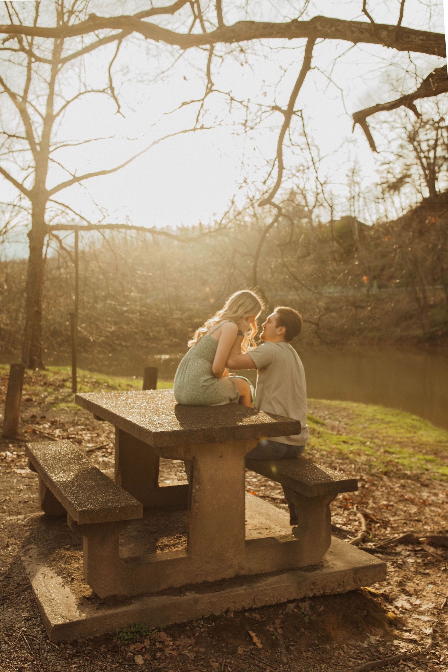 Romantic sunset moment shared on concrete picnic table in nature.