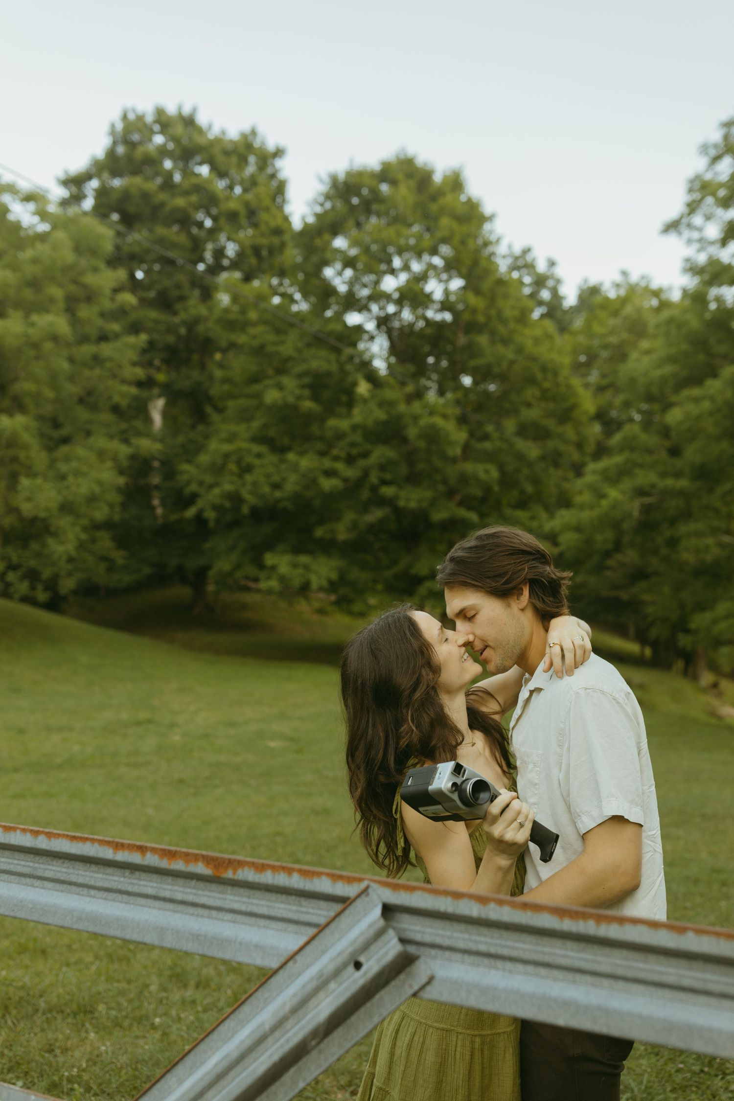 Romantic couple shares an intimate moment against a backdrop of lush greenery.