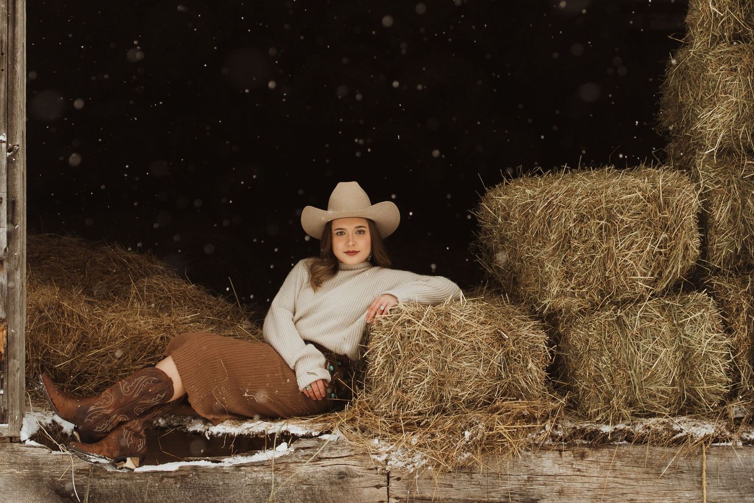 A cozy winter barn scene with hay bales and rustic details.