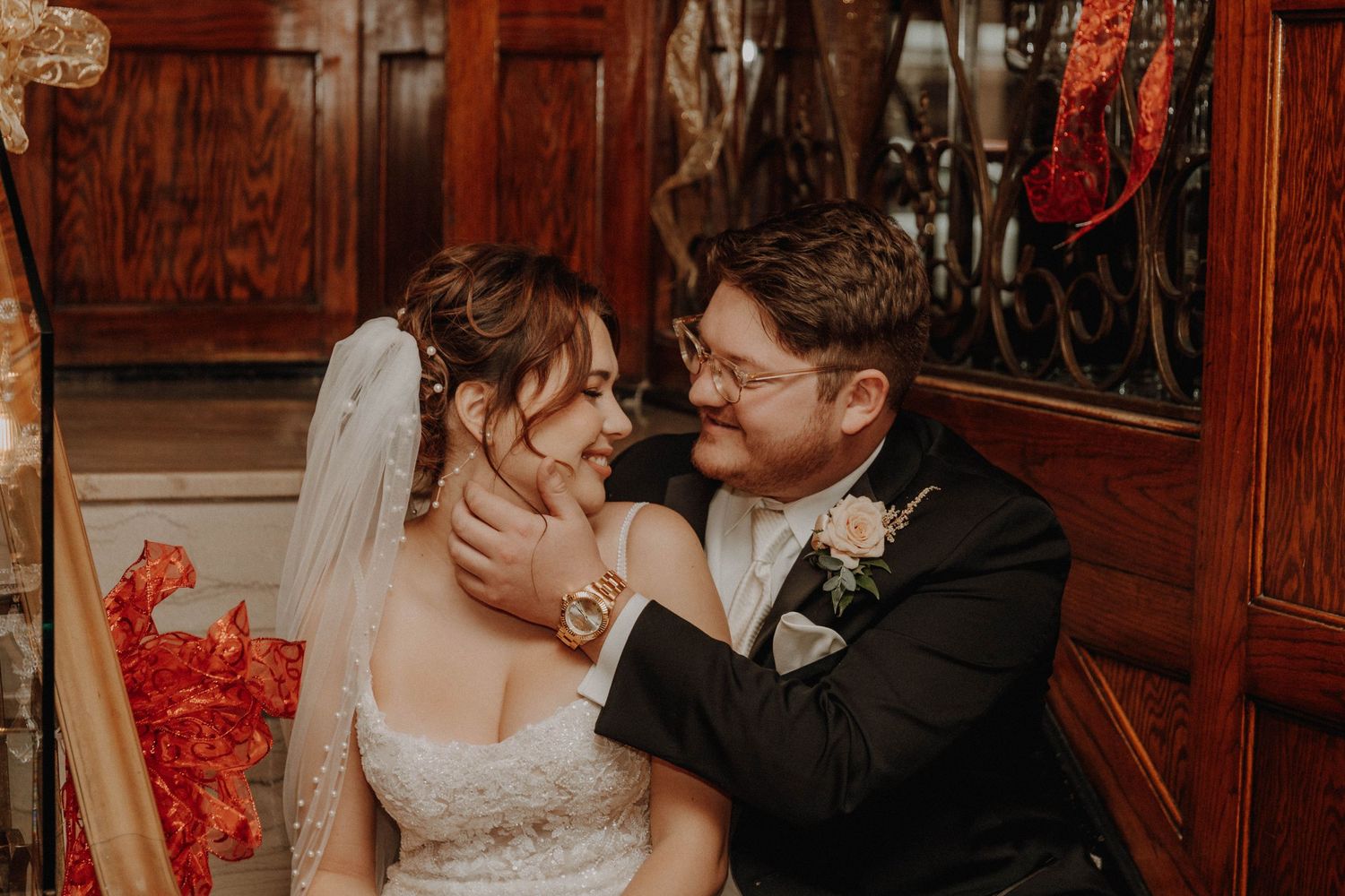 A romantic couple shares an intimate moment in an ornate room with red decor details.