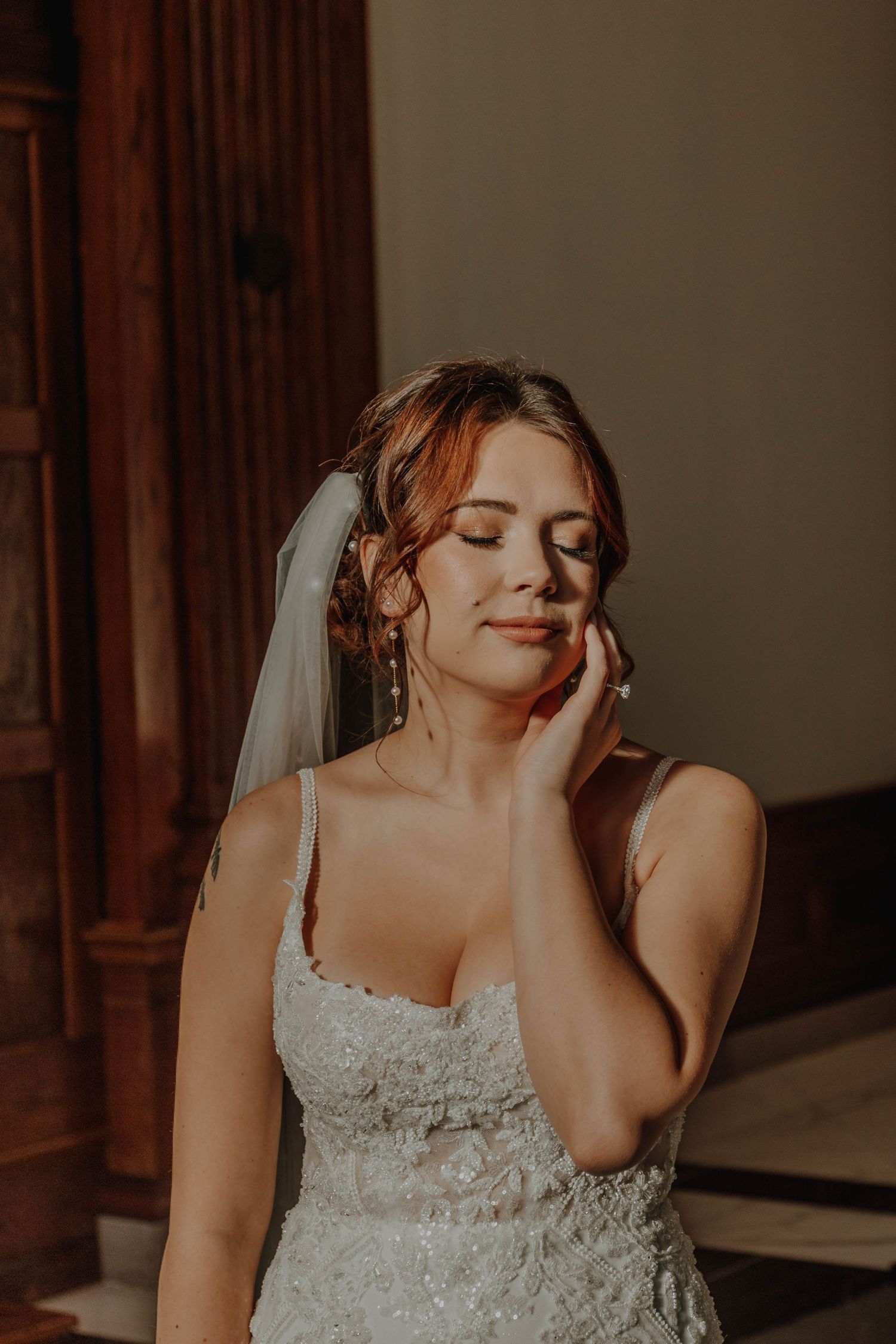Dreamy bridal portrait in a lace gown with soft natural lighting.