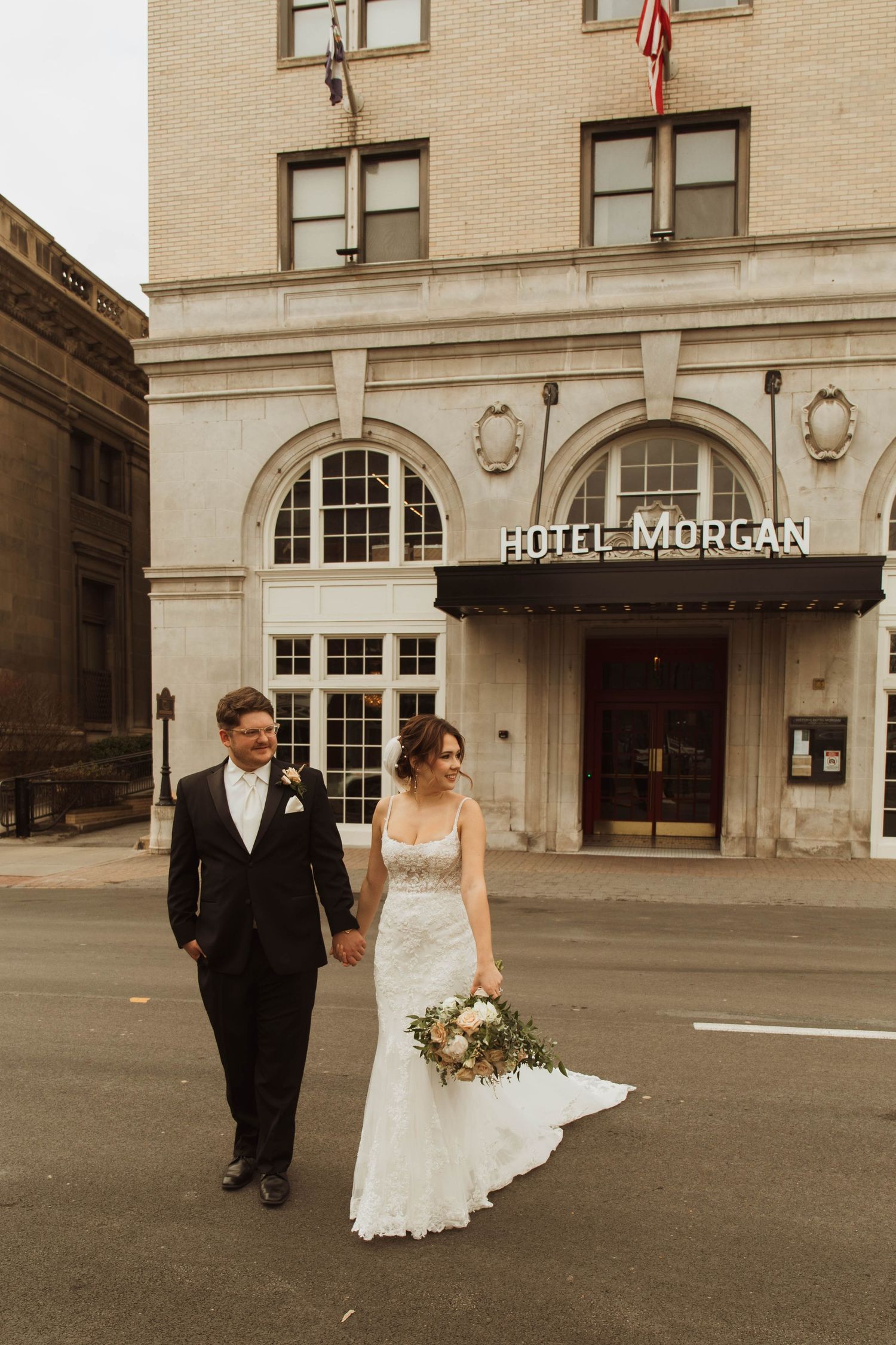 A couple strolls along the sidewalk outside the historic Hotel Morgan.