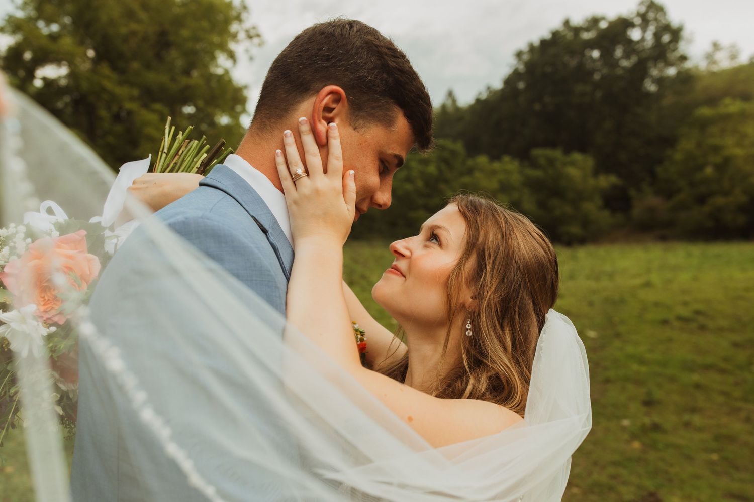 A romantic wedding portrait captured through delicate veil fabric.