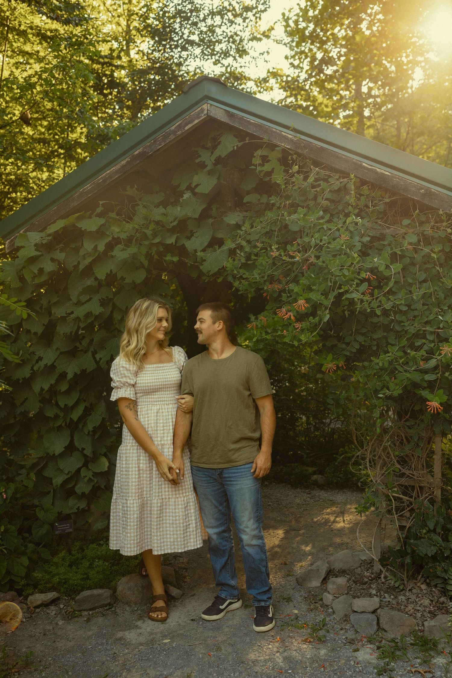 Romantic moment in front of an ivy-covered structure during golden hour.