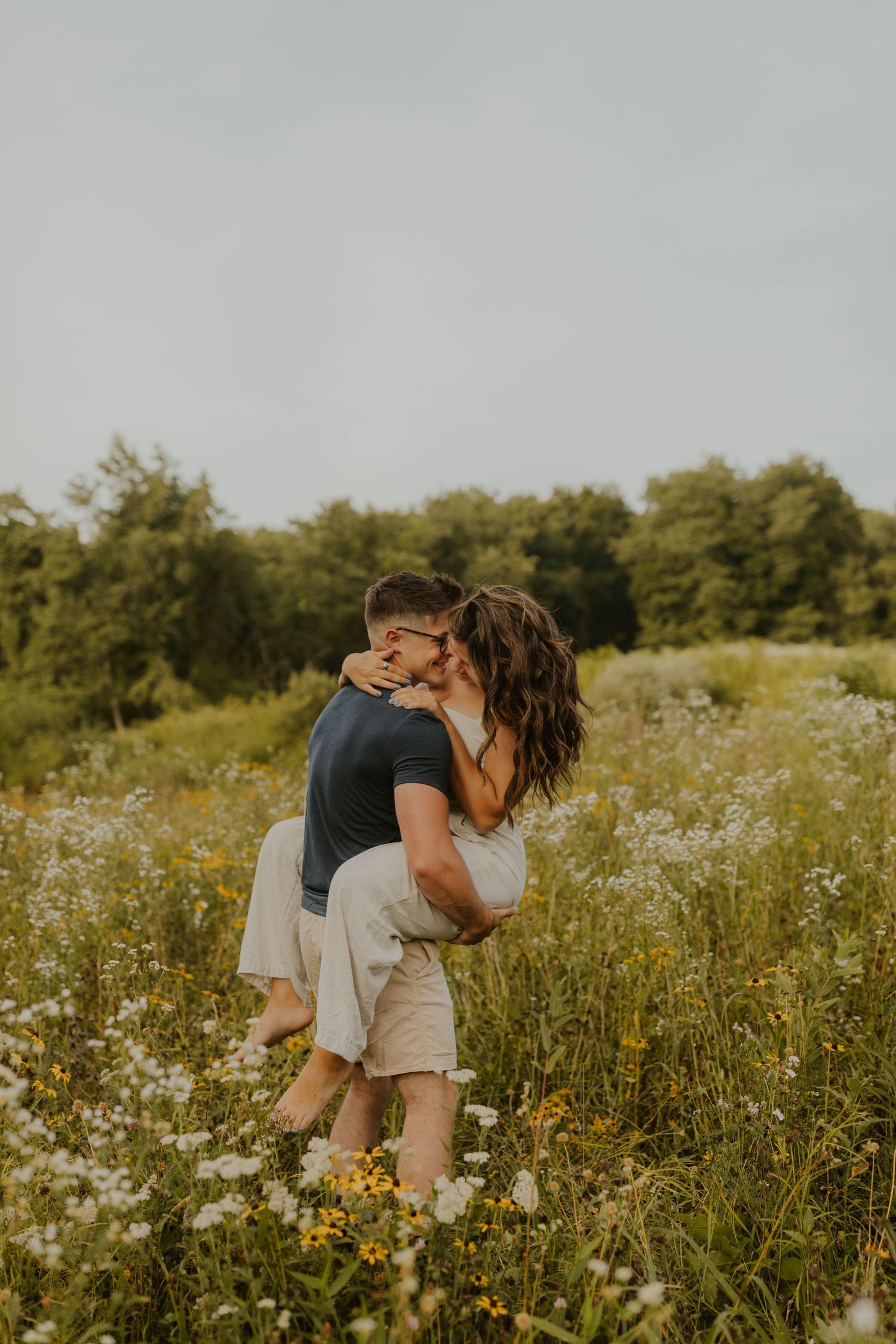 A romantic embrace in a wildflower meadow during golden hour.