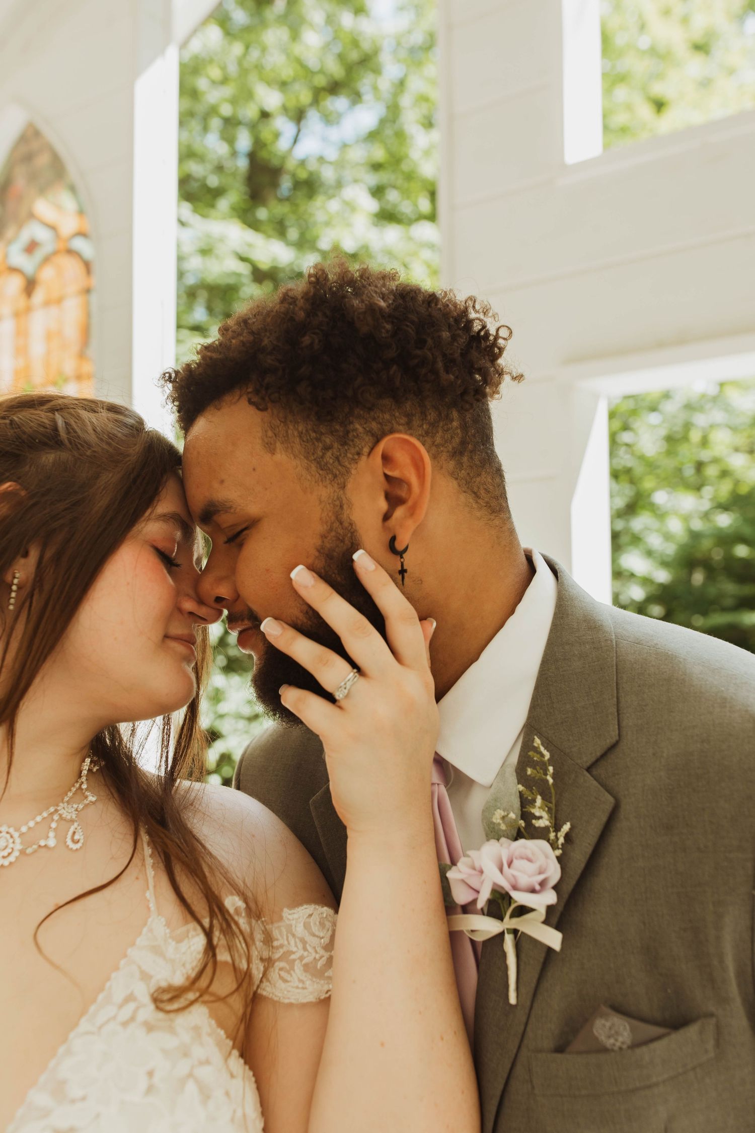 Intimate wedding portrait captured inside a bright white chapel with ornate details.