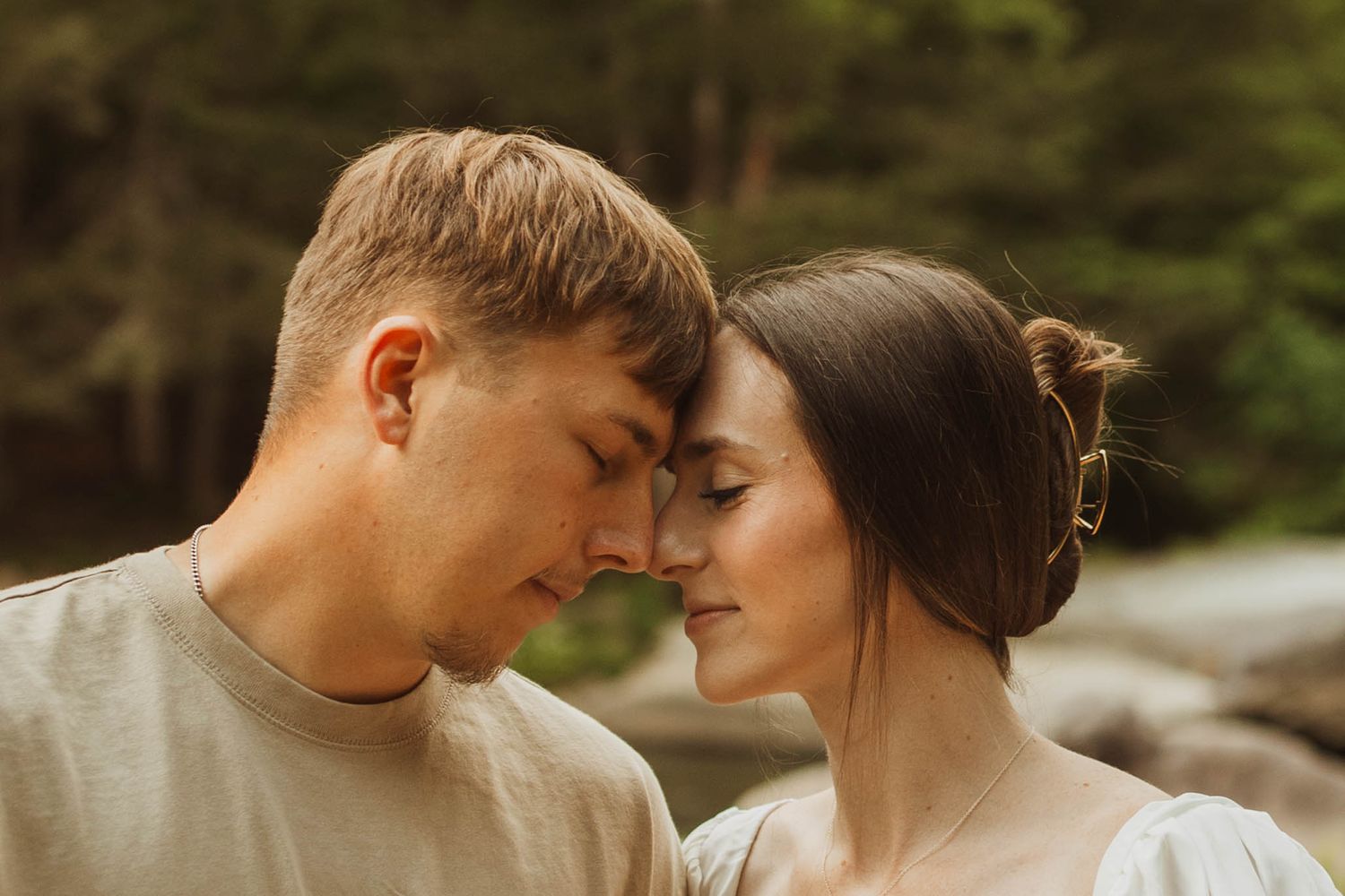 Intimate portrait of a tender romantic moment outdoors in warm sunlight.