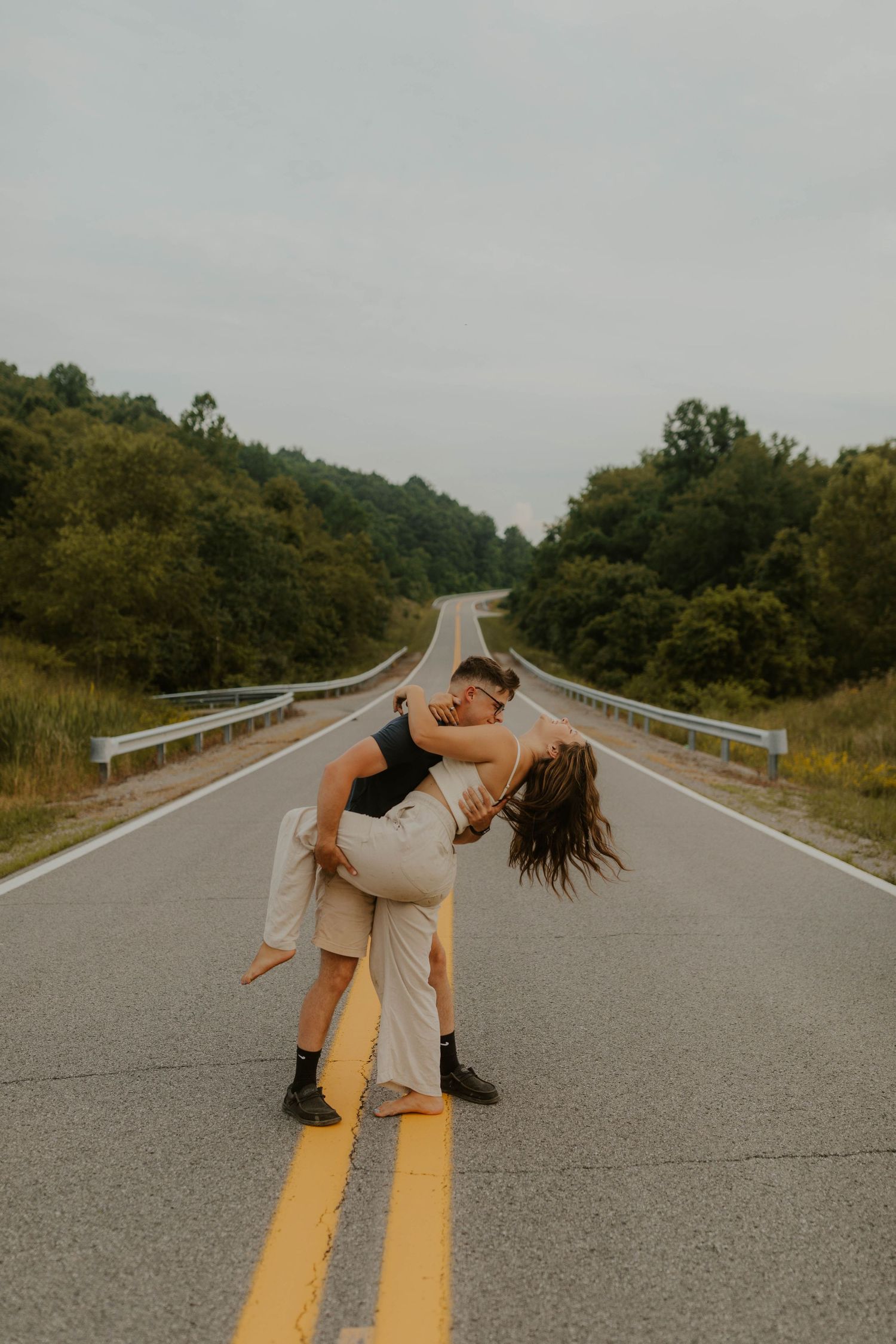 A romantic dip pose on a empty rural road surrounded by rolling hills.