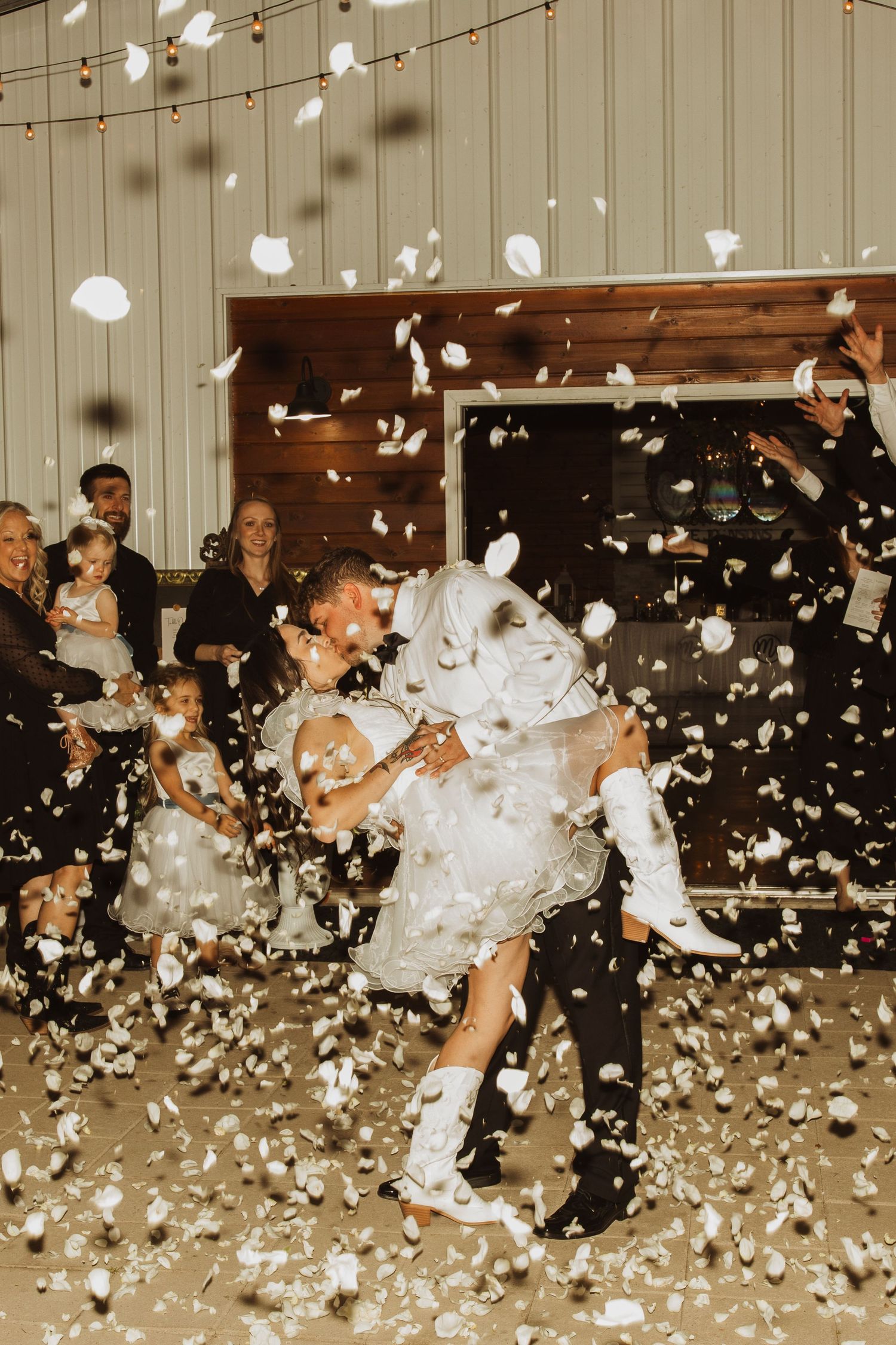 Joyful wedding exit with confetti shower and guests celebrating the newlyweds.