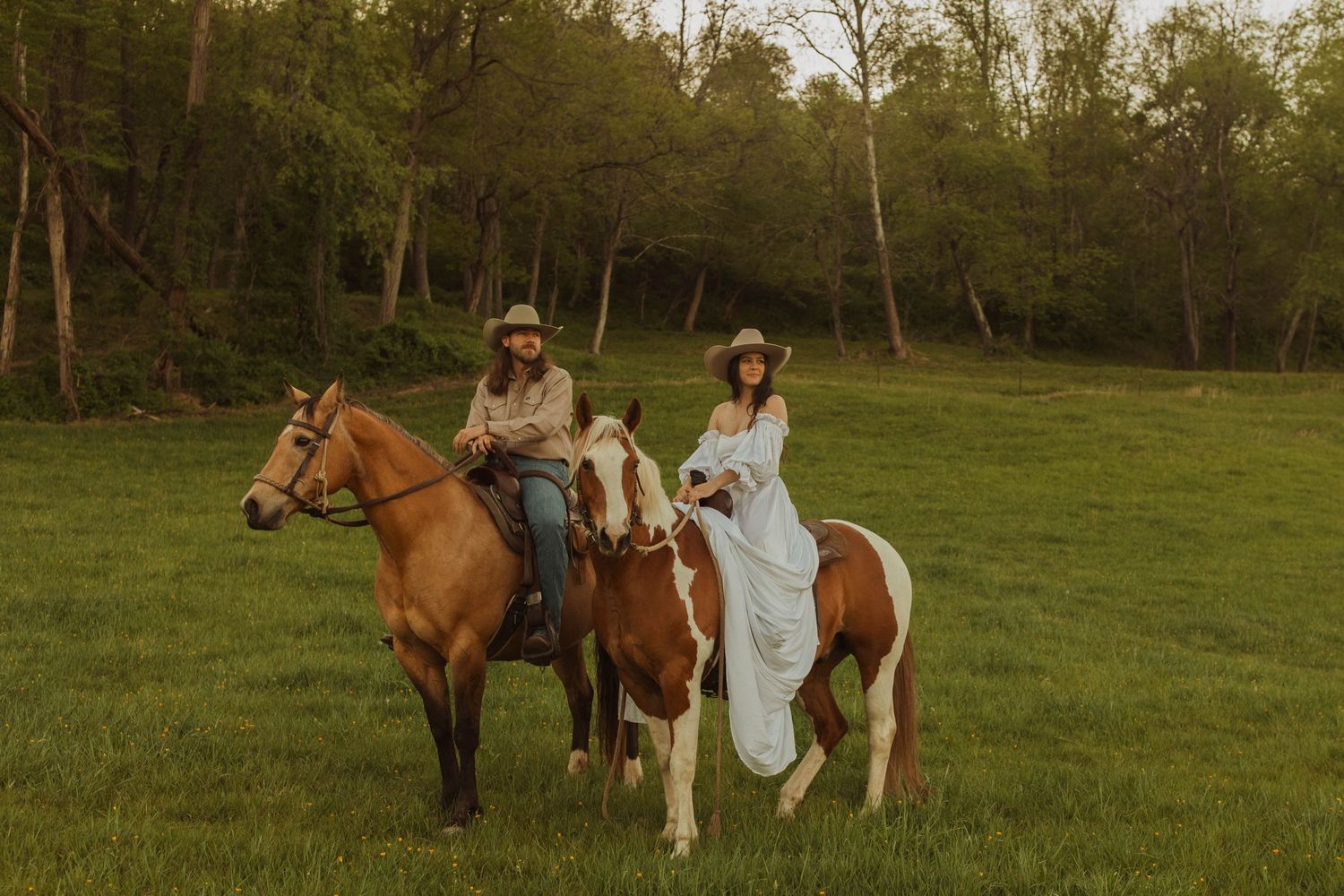 Two riders on horseback enjoy a scenic countryside trail ride.