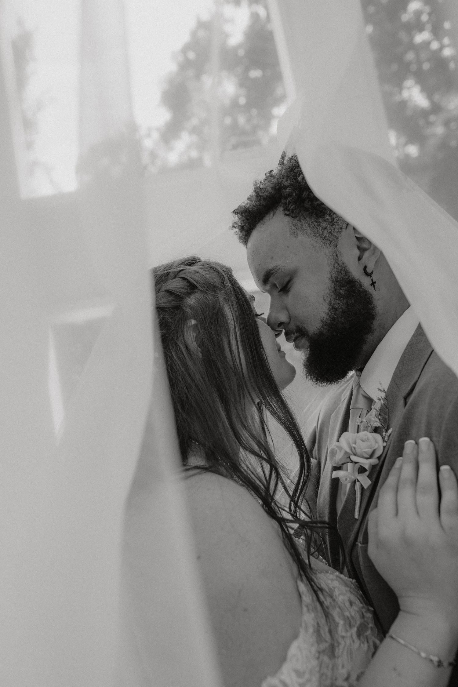 Intimate black and white wedding portrait with soft lighting and romantic styling.