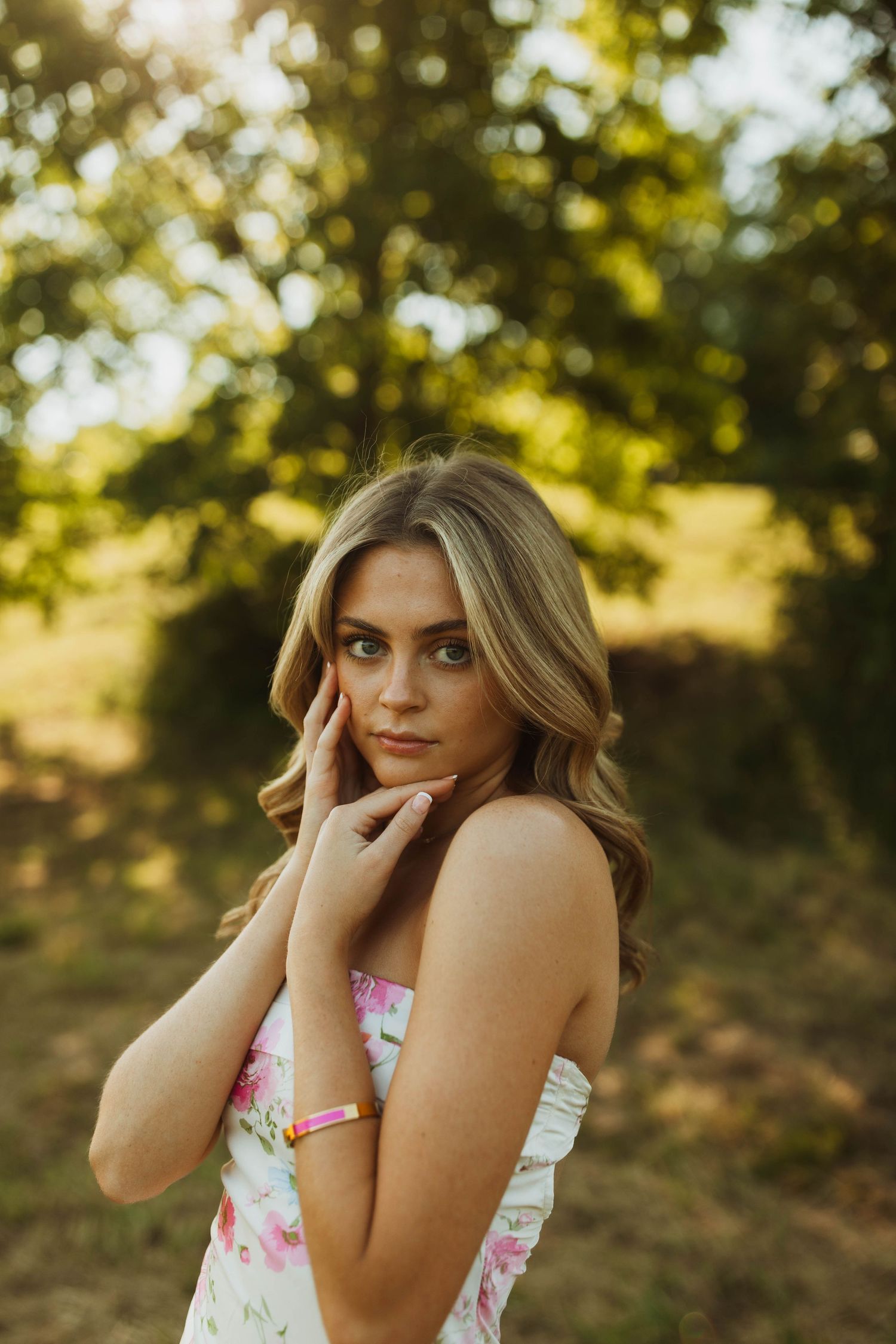 Soft golden light illuminates a portrait against a dreamy forest backdrop.