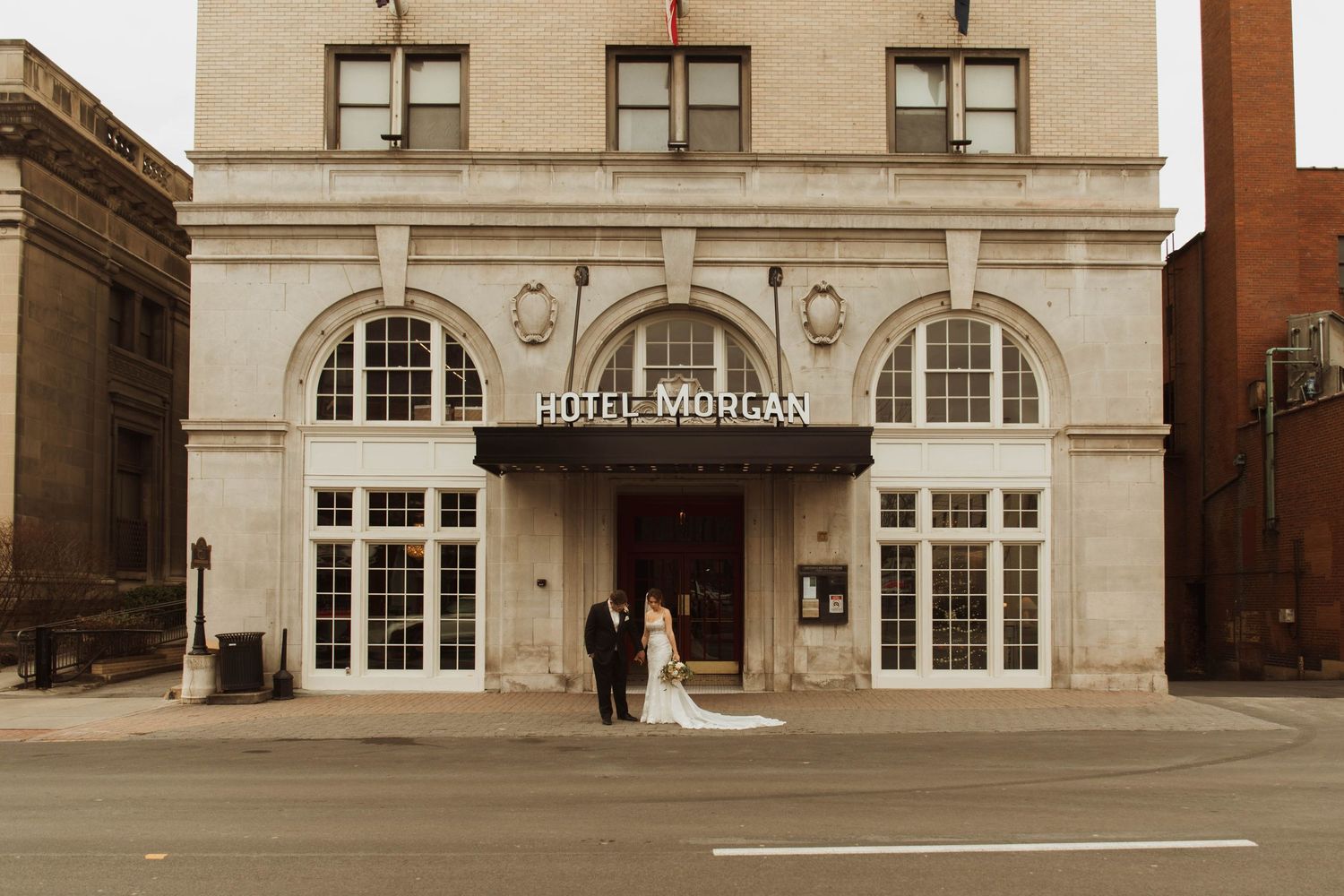 A sepia-toned wedding photo outside the elegant Hotel Morgan building.