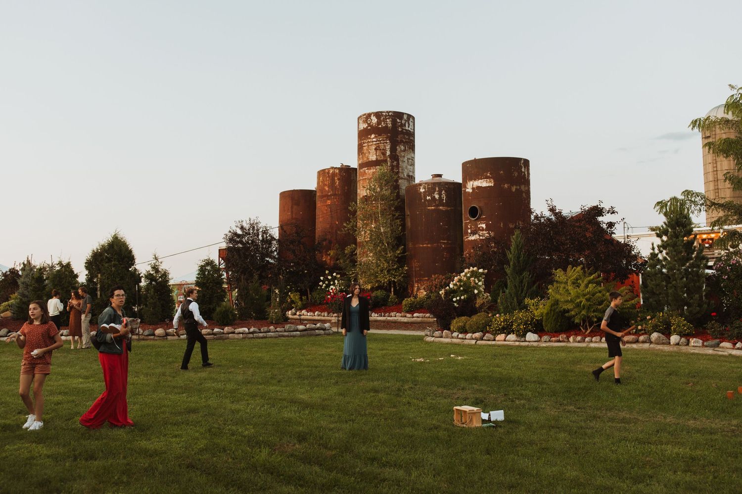 People playing lawn games outside a rustic brick castle structure.
