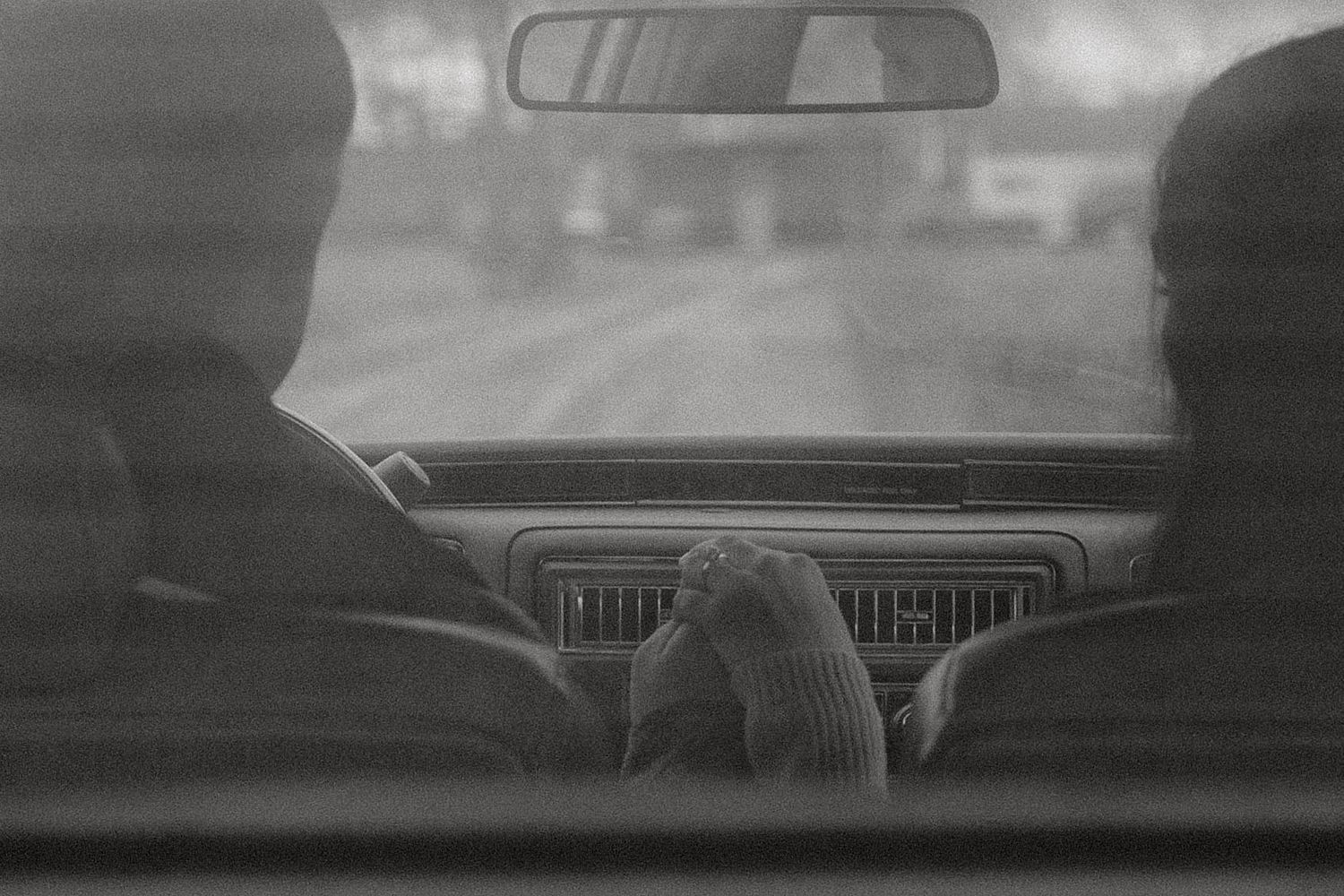 Interior view of a classic car dashboard shot from behind in black and white.