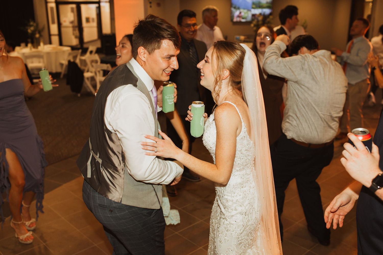 Couple shares intimate dance moment at dimly lit wedding reception.
