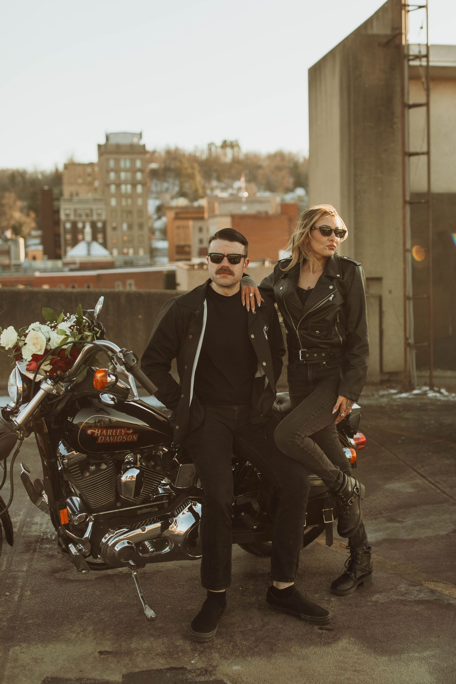 A motorcycle is parked on an urban rooftop with city buildings visible in the background.