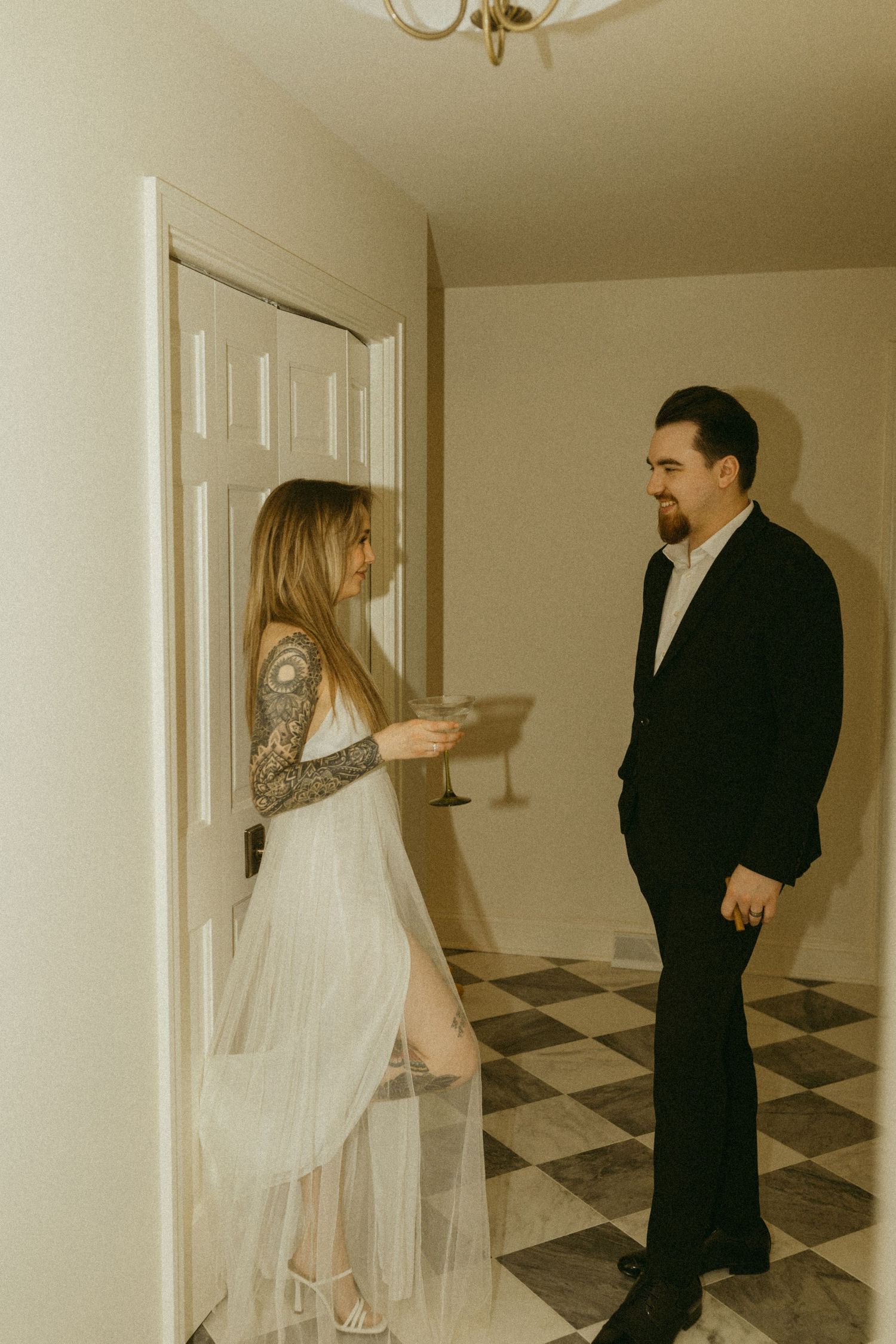 Couple in formal attire sharing conversation in vintage-styled interior.