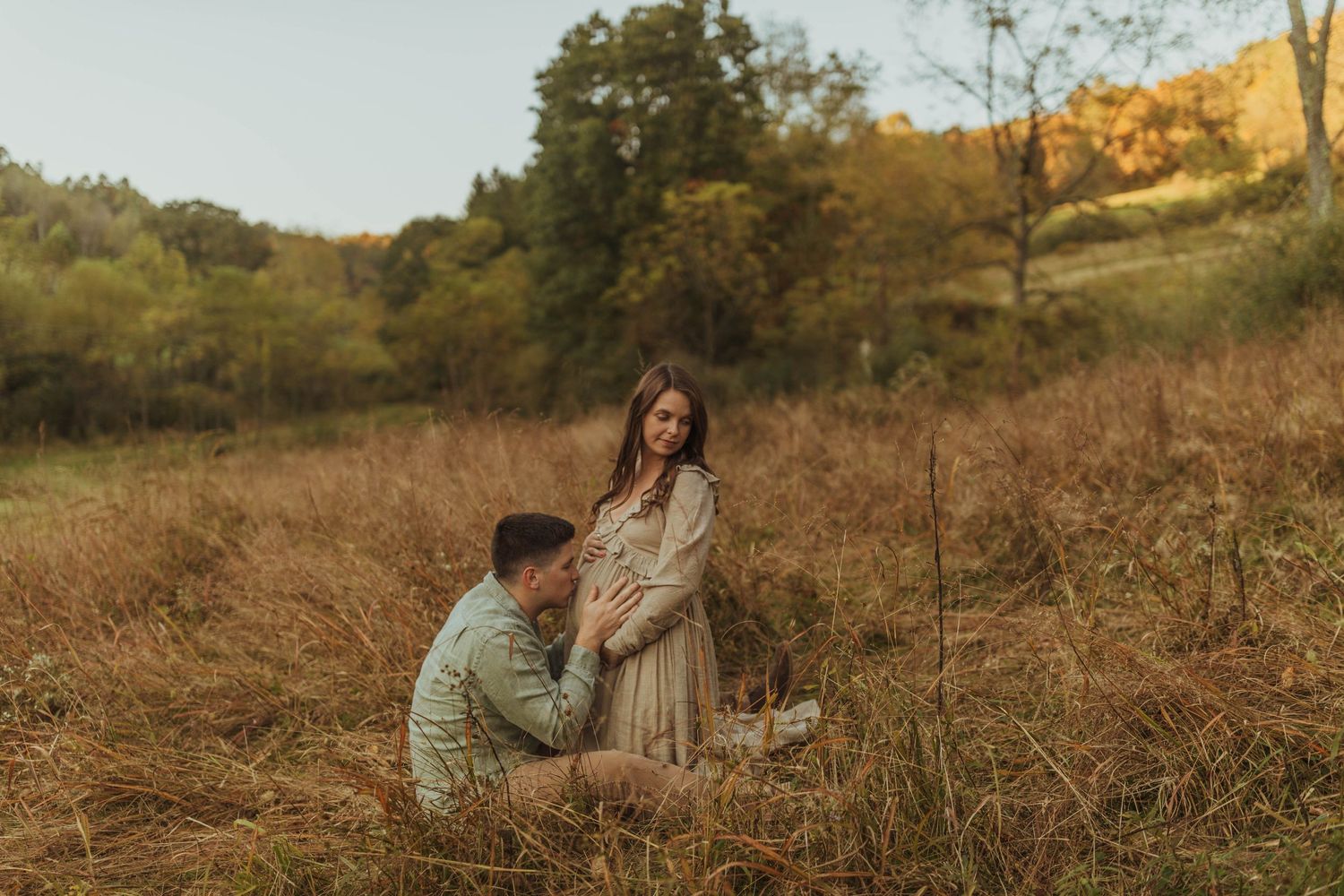Couple sharing special moment in autumn field during golden hour.