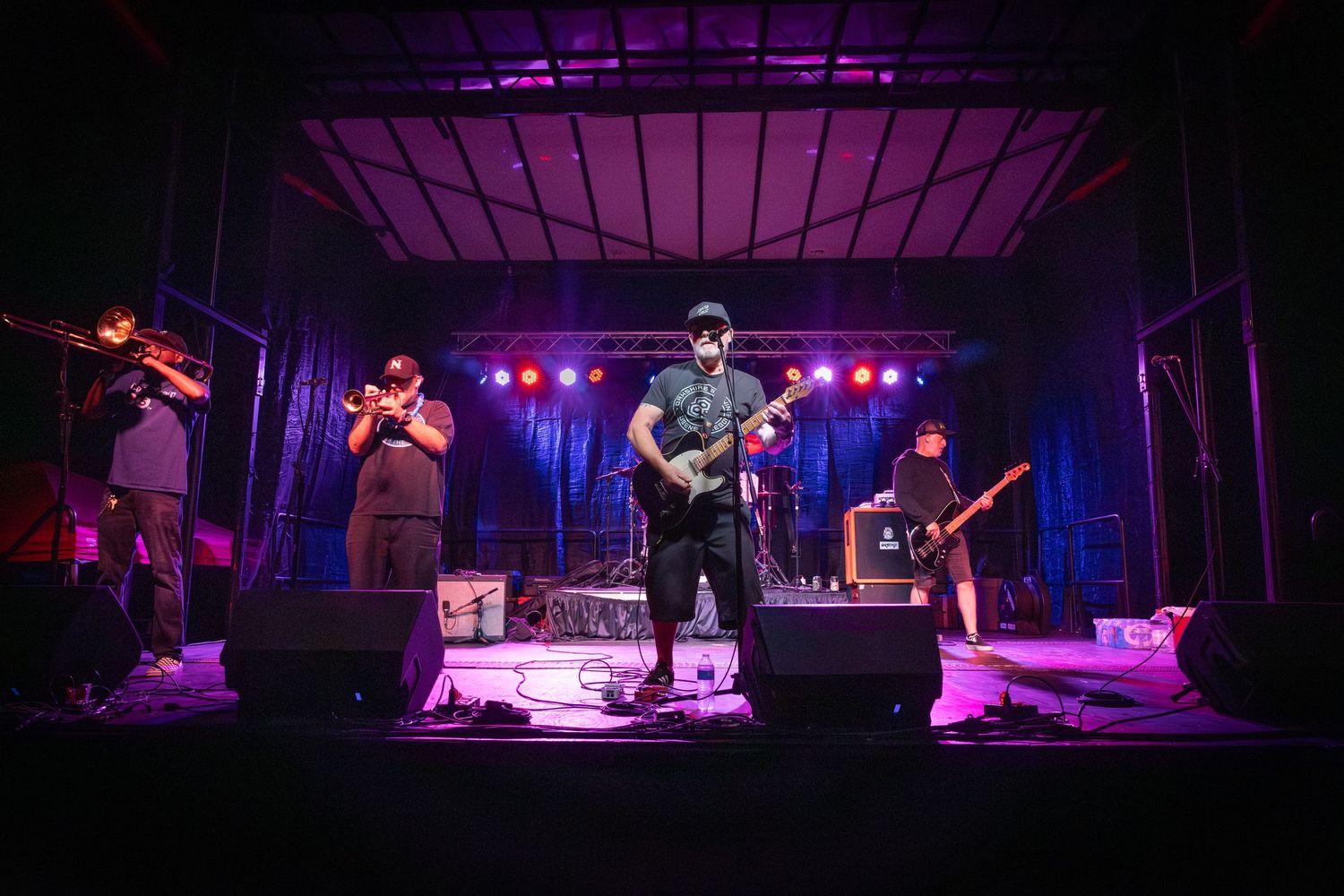 Live band performing on stage during a concert with colorful stage lighting.  The Toasters