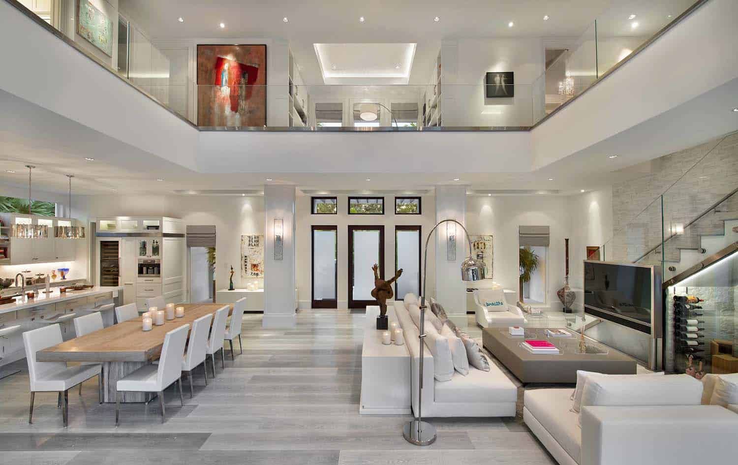 Contemporary two-story great room with floating staircase, modern furniture, and dramatic double-height ceilings.
