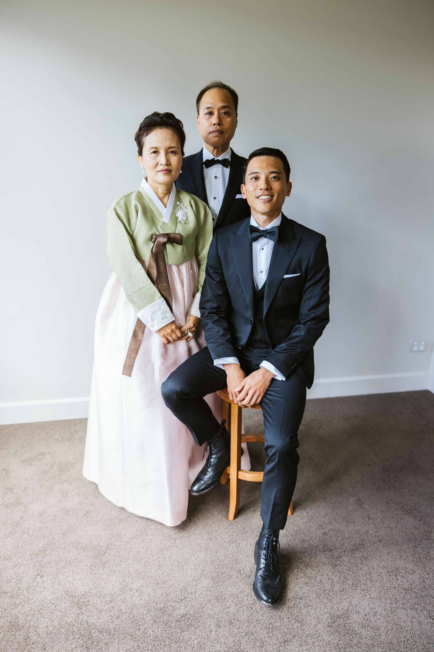 A family portrait featuring traditional Korean hanbok and modern formal attire.