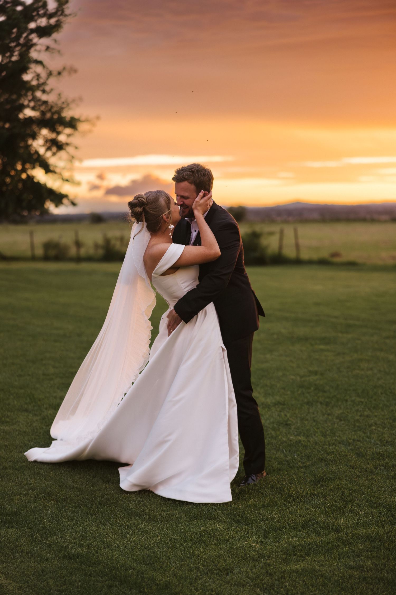 Intimate embrace between couple during sunset wedding photoshoot.