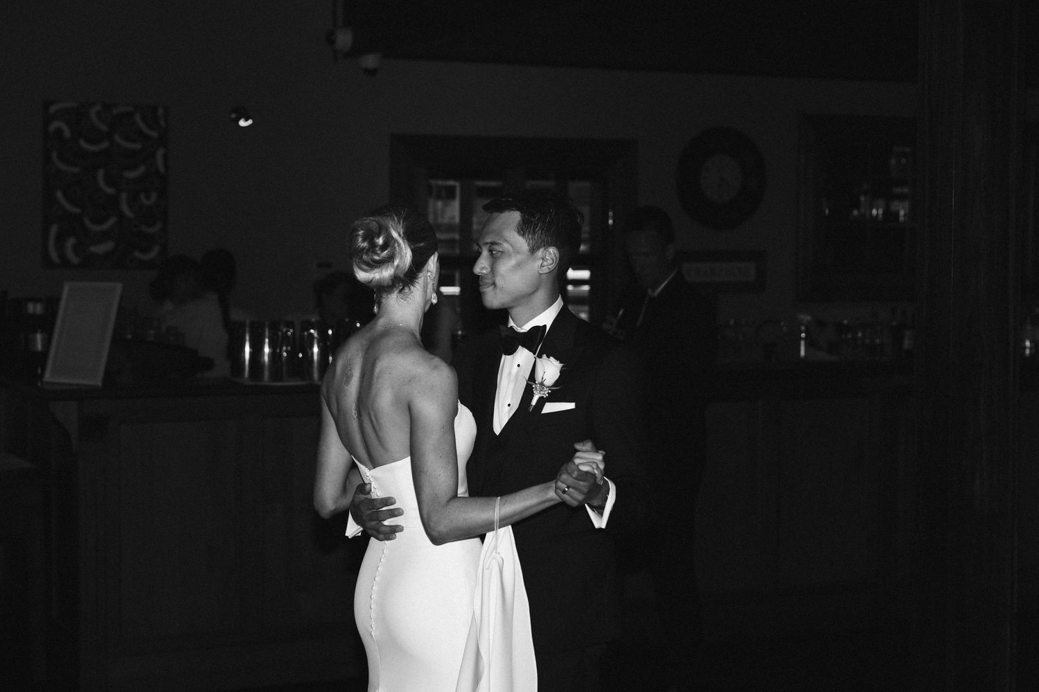 Intimate black and white photo of couple's first dance at wedding reception.