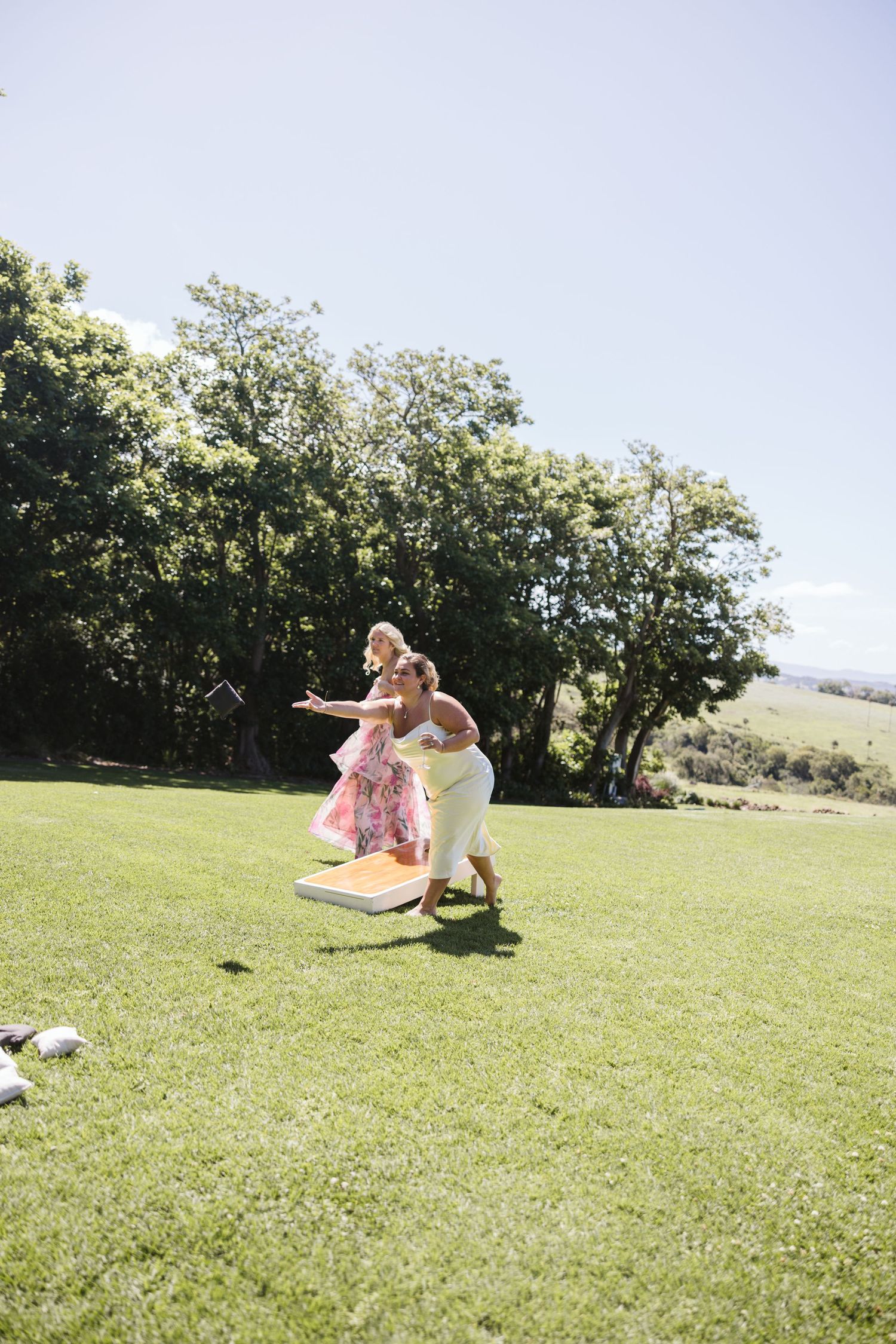 Playful guests jumping on grass during outdoor celebration.