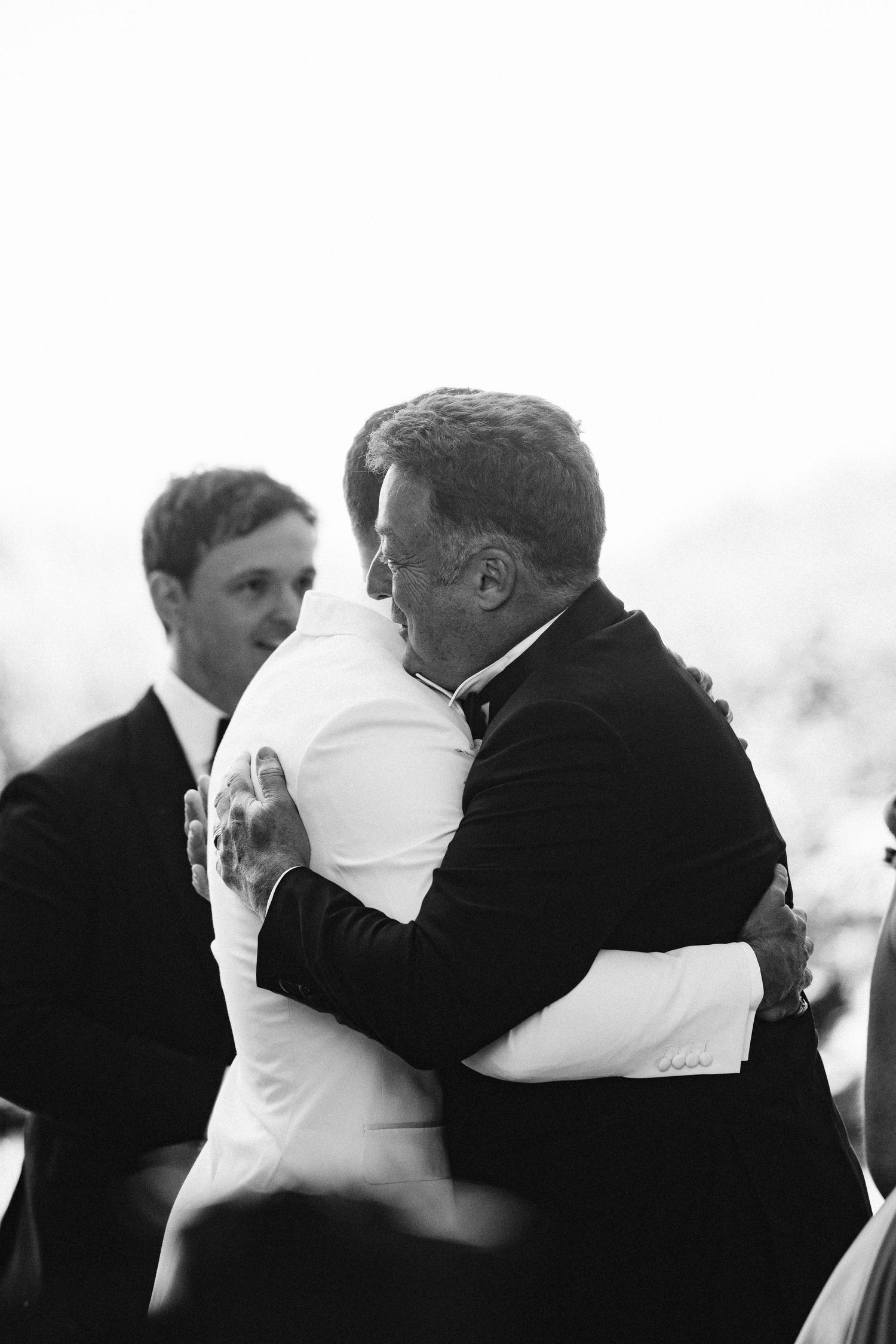 Emotional black and white photo of wedding embrace during ceremony.