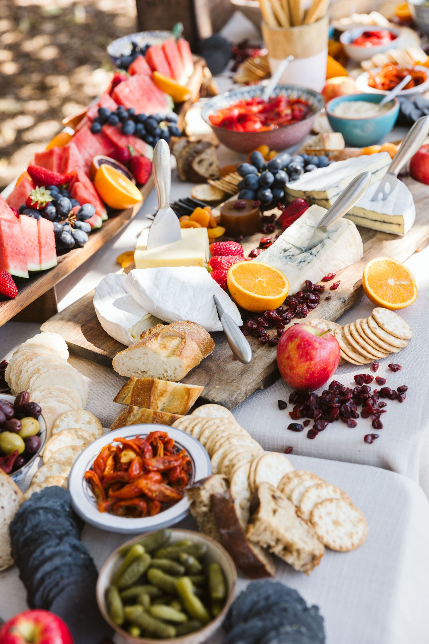 A colorful grazing platter with fresh fruits, cheeses, crackers, and assorted snacks.