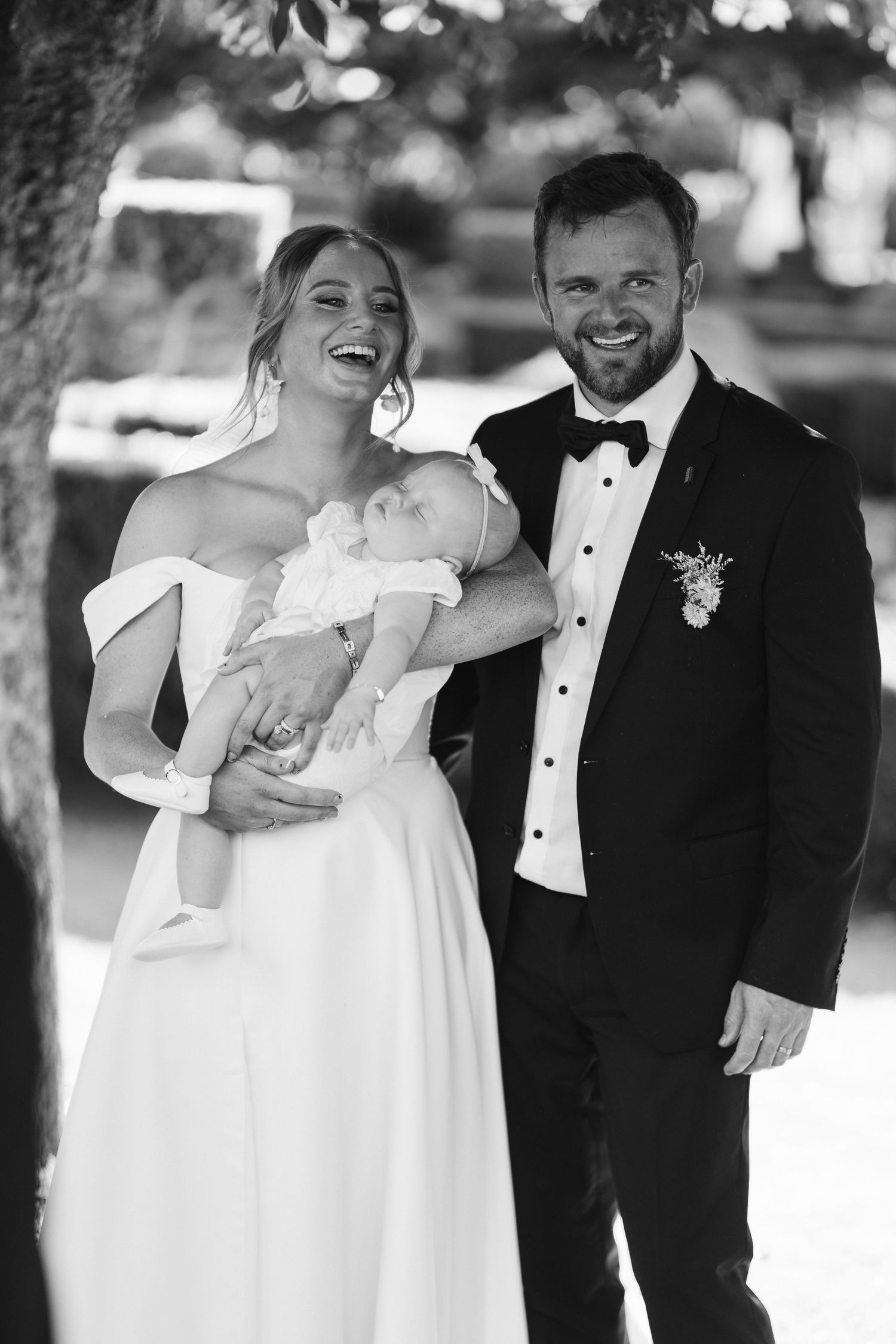 Joyful wedding portrait captured outdoors under natural lighting.
