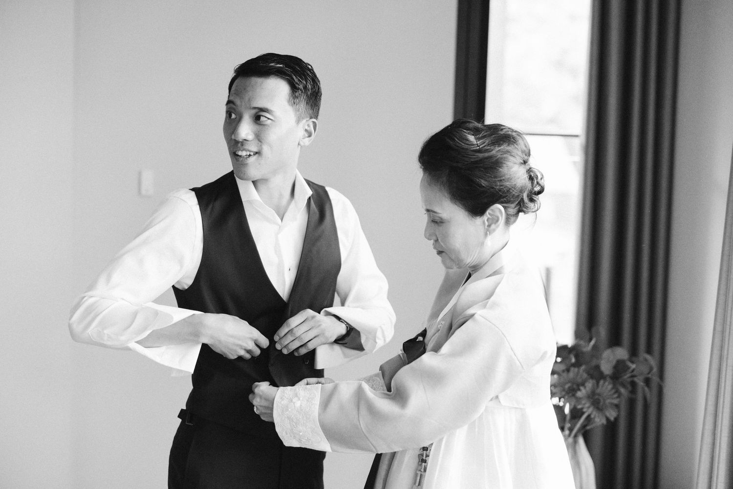 Candid moment captured during wedding preparations in black and white.