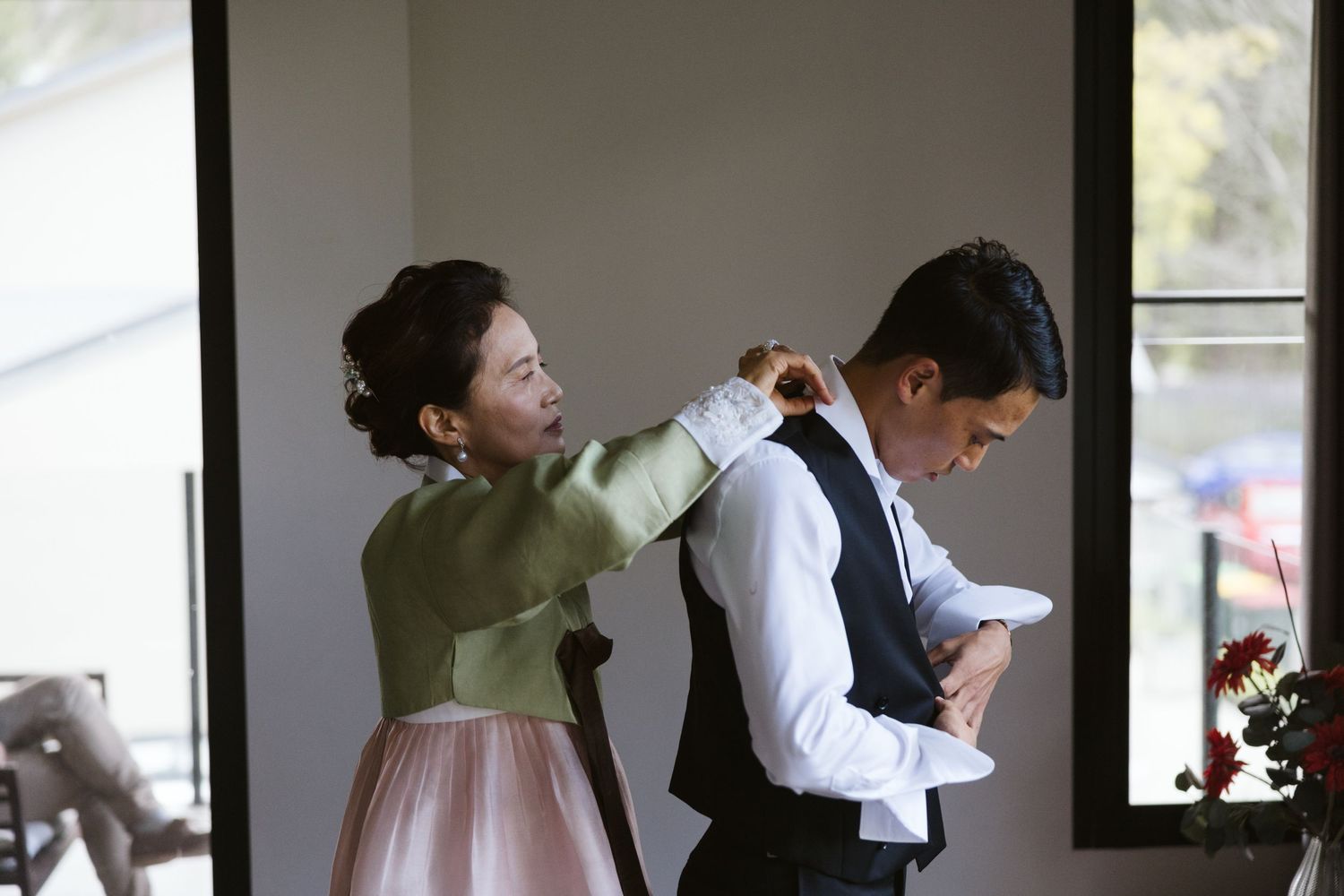 Wedding day preparations as final adjustments are made to formal attire.