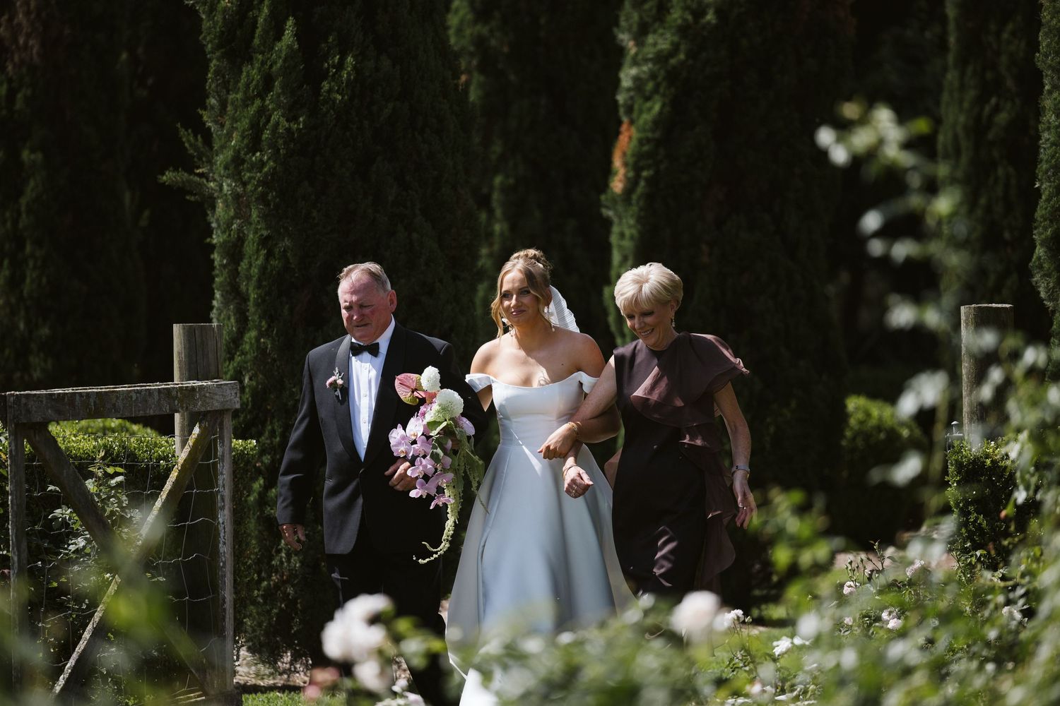 An outdoor garden ceremony with cypress trees creating a natural backdrop.