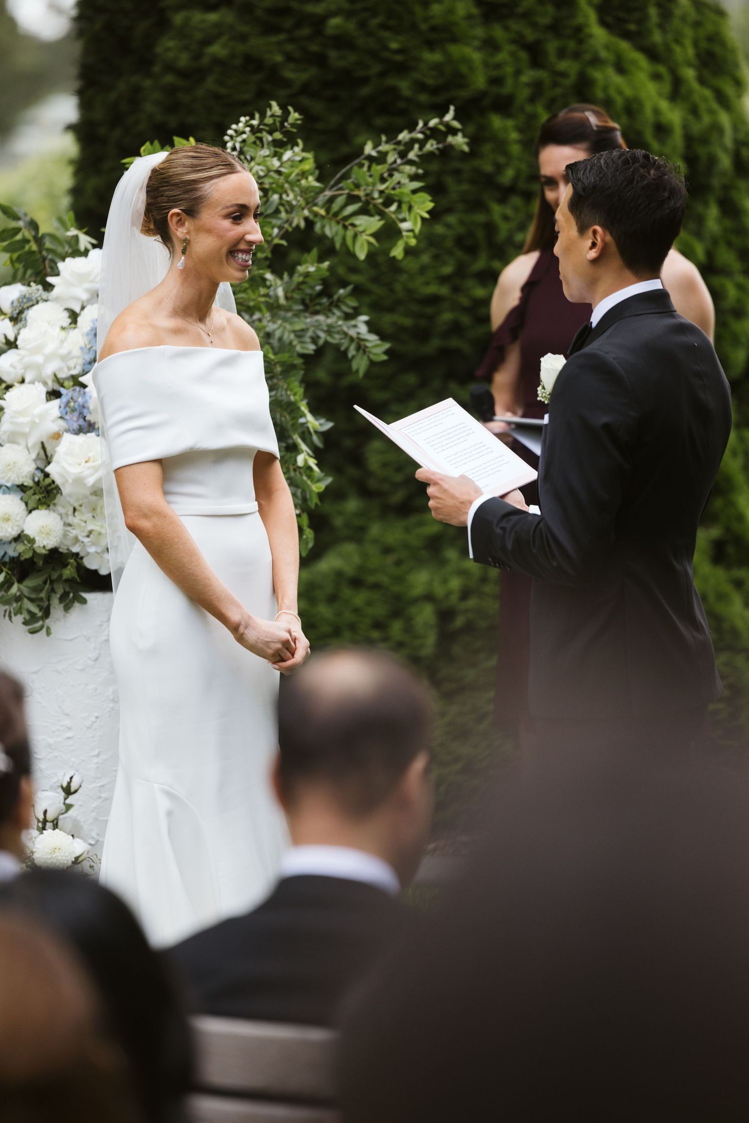 Garden wedding ceremony with white floral arrangements and elegant decorations.